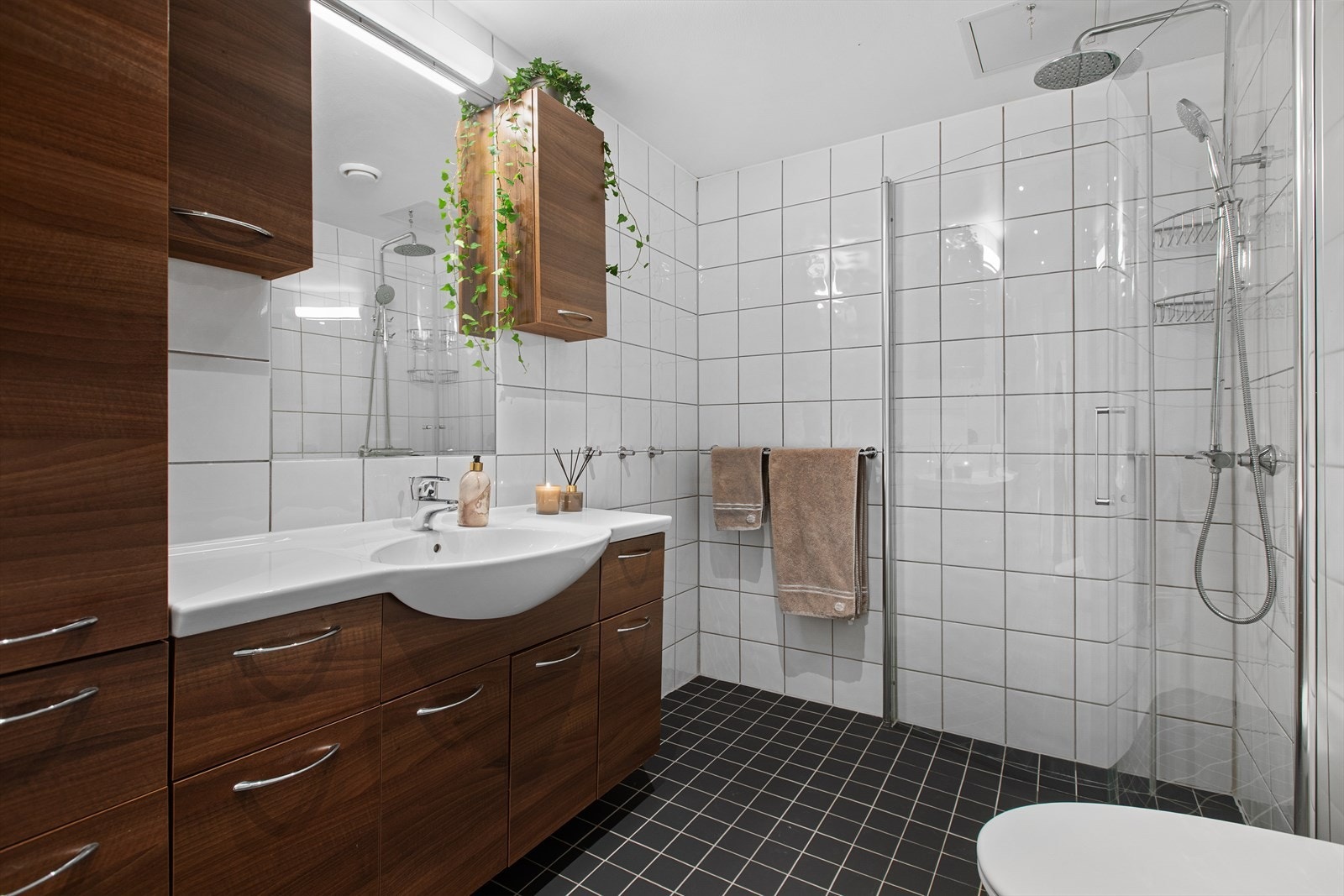 Badet i første etasje har dusjhjørne med glassdører og god skapplass i innredningen. Badet har behagelig gulvvarme Galleribilde