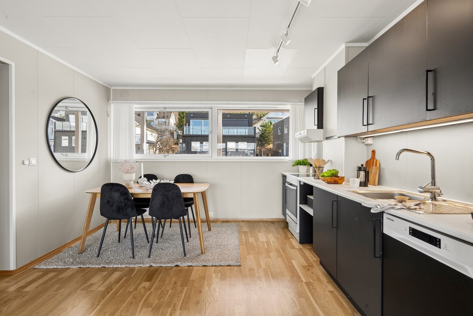 Kjøkkenet er tidløst innredet med sorte, slette fronter og lys benkeplate i laminat. Kjøkkenet er godt utnyttet og gir god lagringsplass i skap. Galleribilde