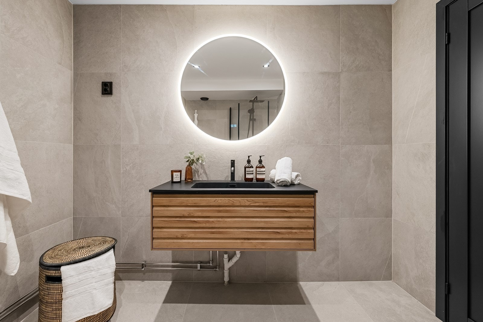 Baderomsinnredning med nedfelt servant og et stort, bakbelyst speil. Downlights i taket ble installert i 2026. Galleribilde