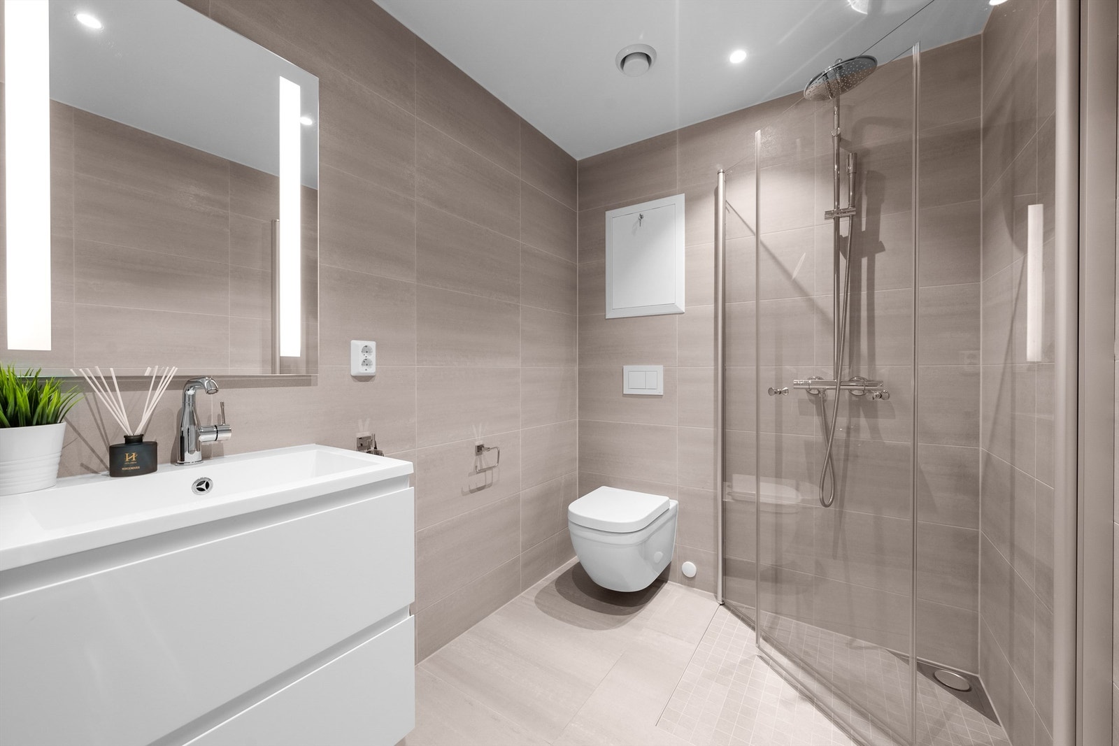 Pent flislagt bad i 1. etasje med downlights og en moderne innredning Galleribilde