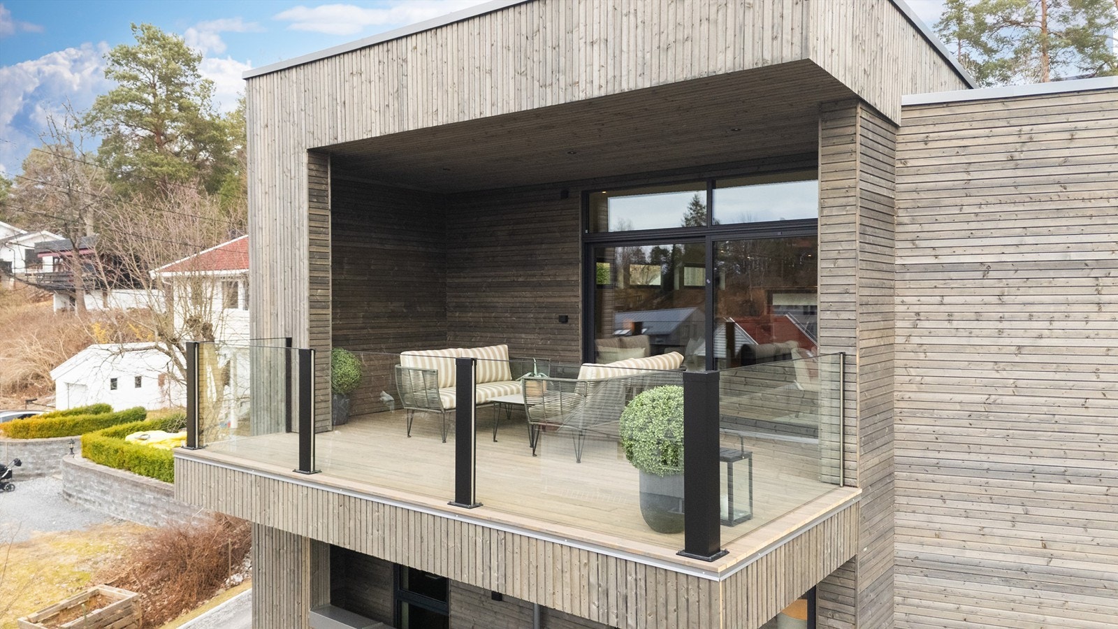 Moderne arkitektur over tre plan, med store balkonger og integrert garasje med innvendig adkomst. Galleribilde