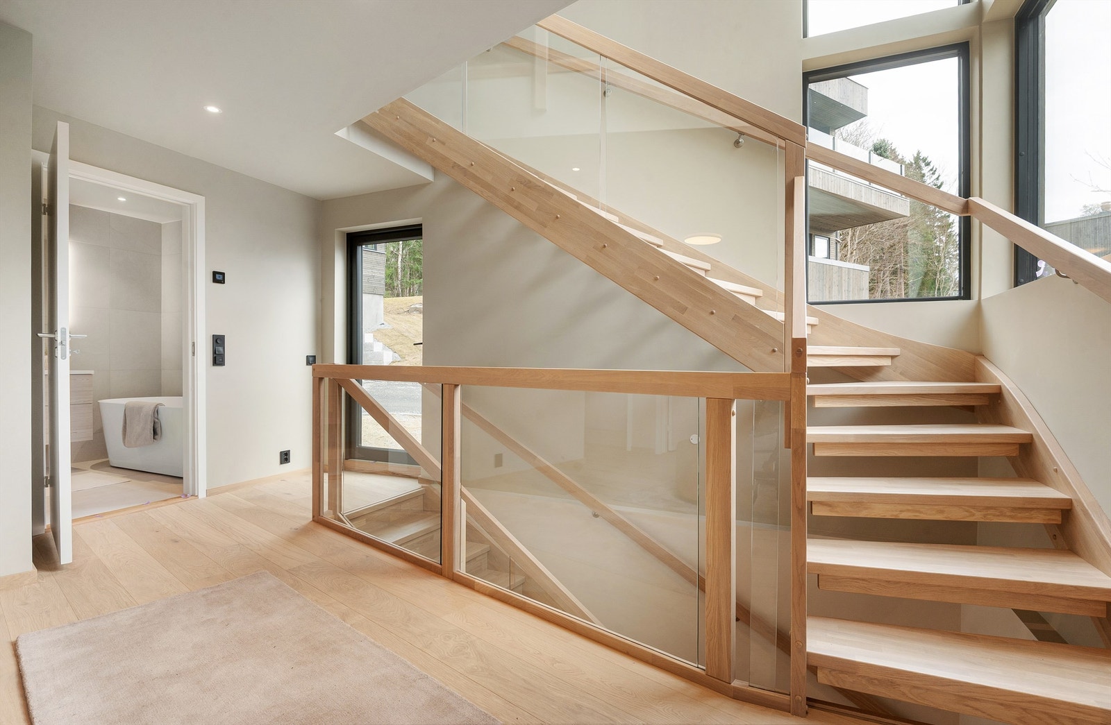 Trapperommet binder etasjene sammen og er lyst og åpent med rekkverk i glass. Galleribilde