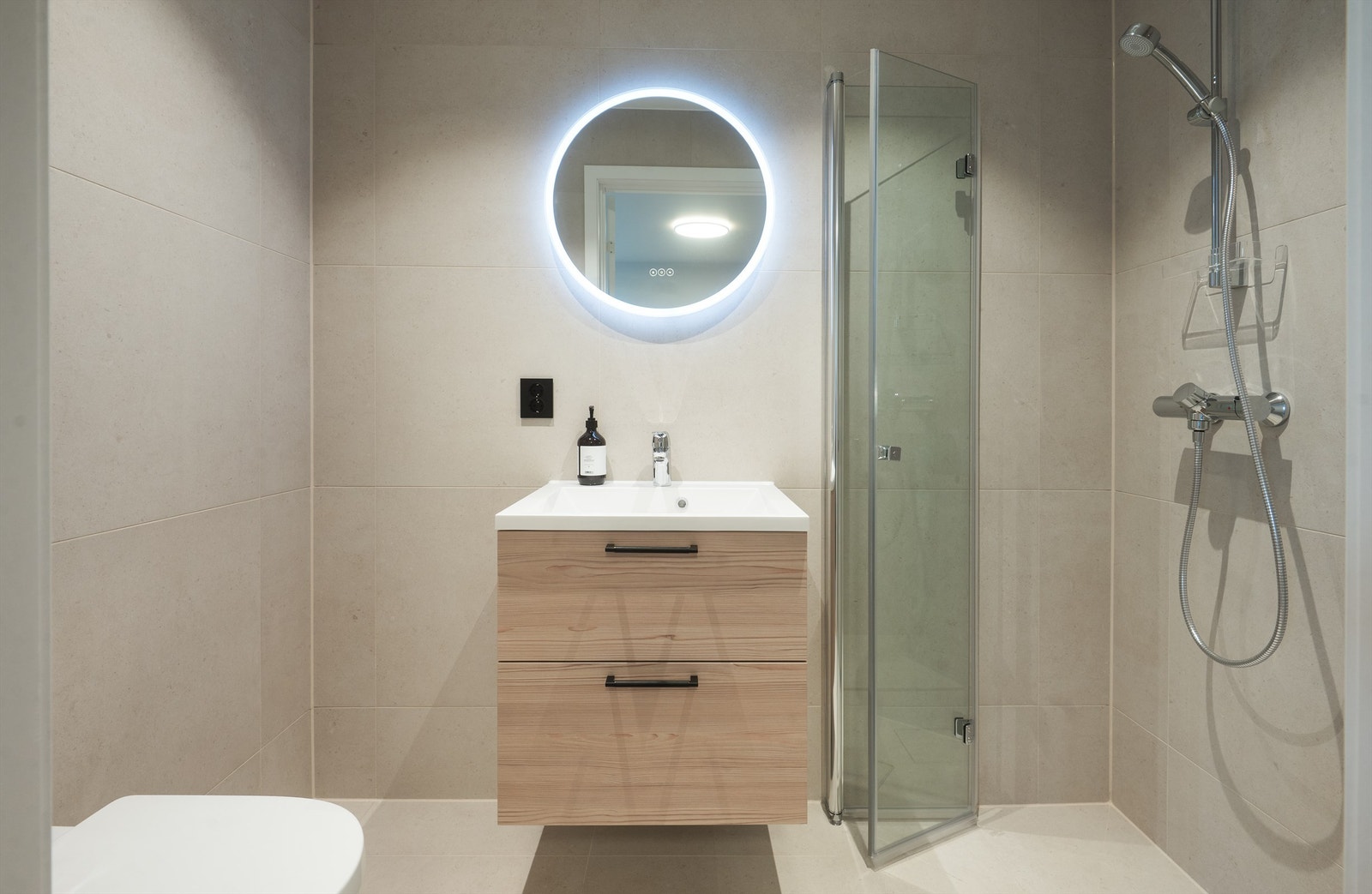 Boligen har totalt tre bad. Dette er badet i underetasjen, praktisk plassert ved inngangspartiet. Galleribilde