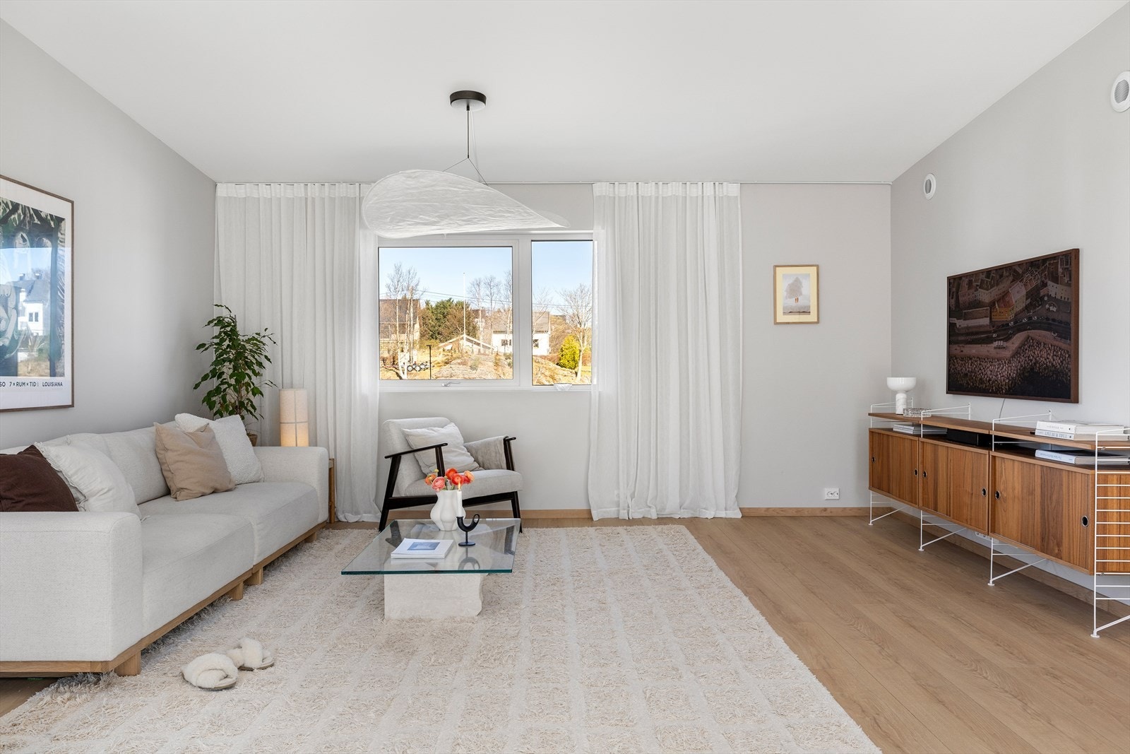 Stuen har det samme lyse preget som spisestuedelen. Her er det etablert gardiner, det er godt med plass til sofagruppe og kommode/tv-benk under tv-en. Galleribilde