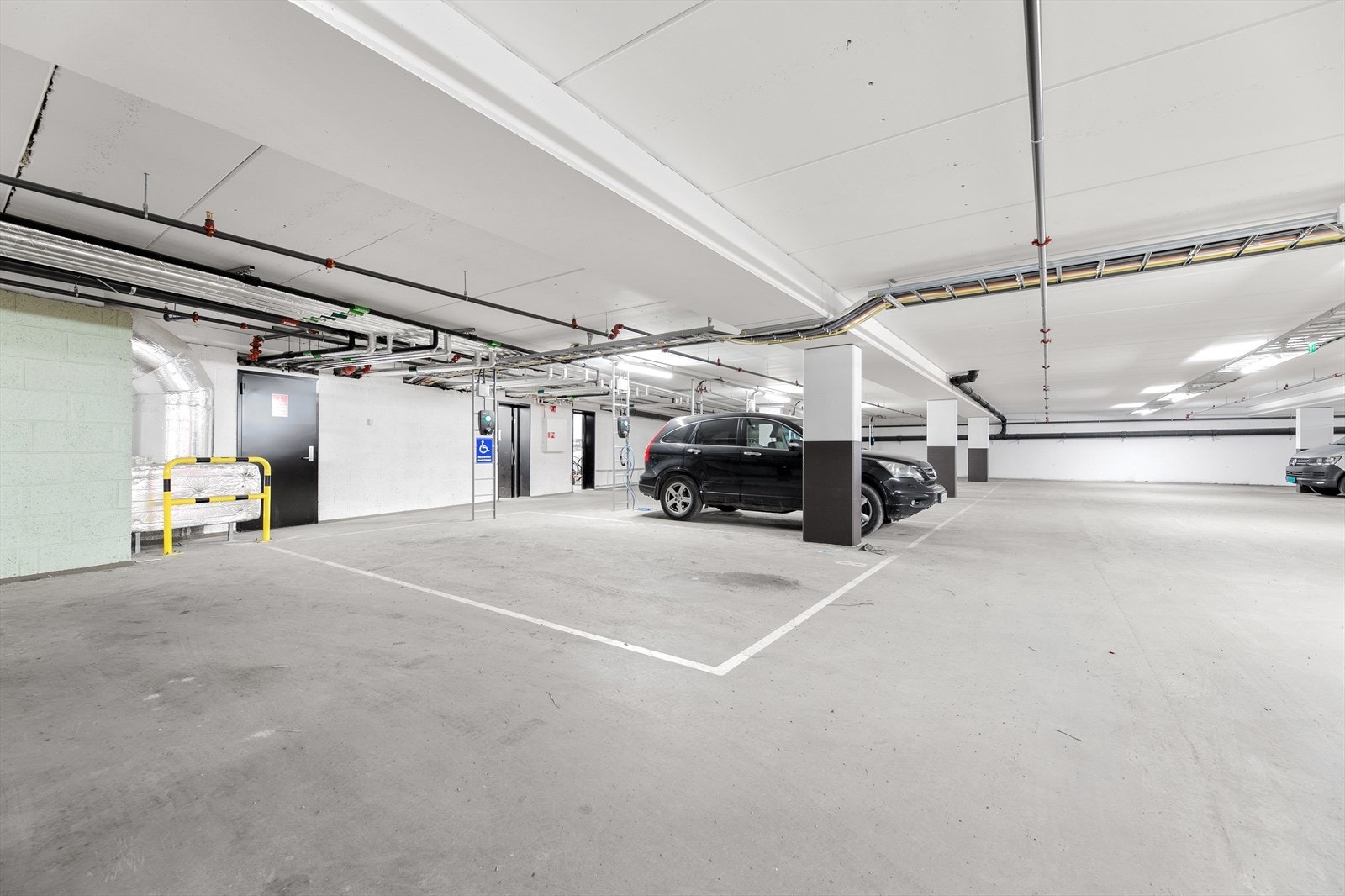 Egen parkeringsplass i felles garasjeanlegg. Plassen er utstyrt med elbillader. Galleribilde