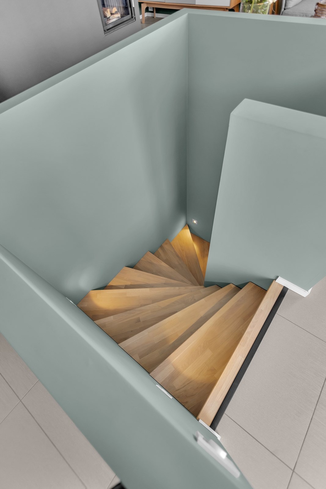 Trinnbelysning langs trappen gir både et visuelt løft og økt trygghet, samtidig som det skaper en koselig atmosfære i rommet. Under trappen finner du praktiske oppbevaringsmuligheter i et kott - et ideelt sted for å holde ting som ikke brukes daglig. Galleribilde