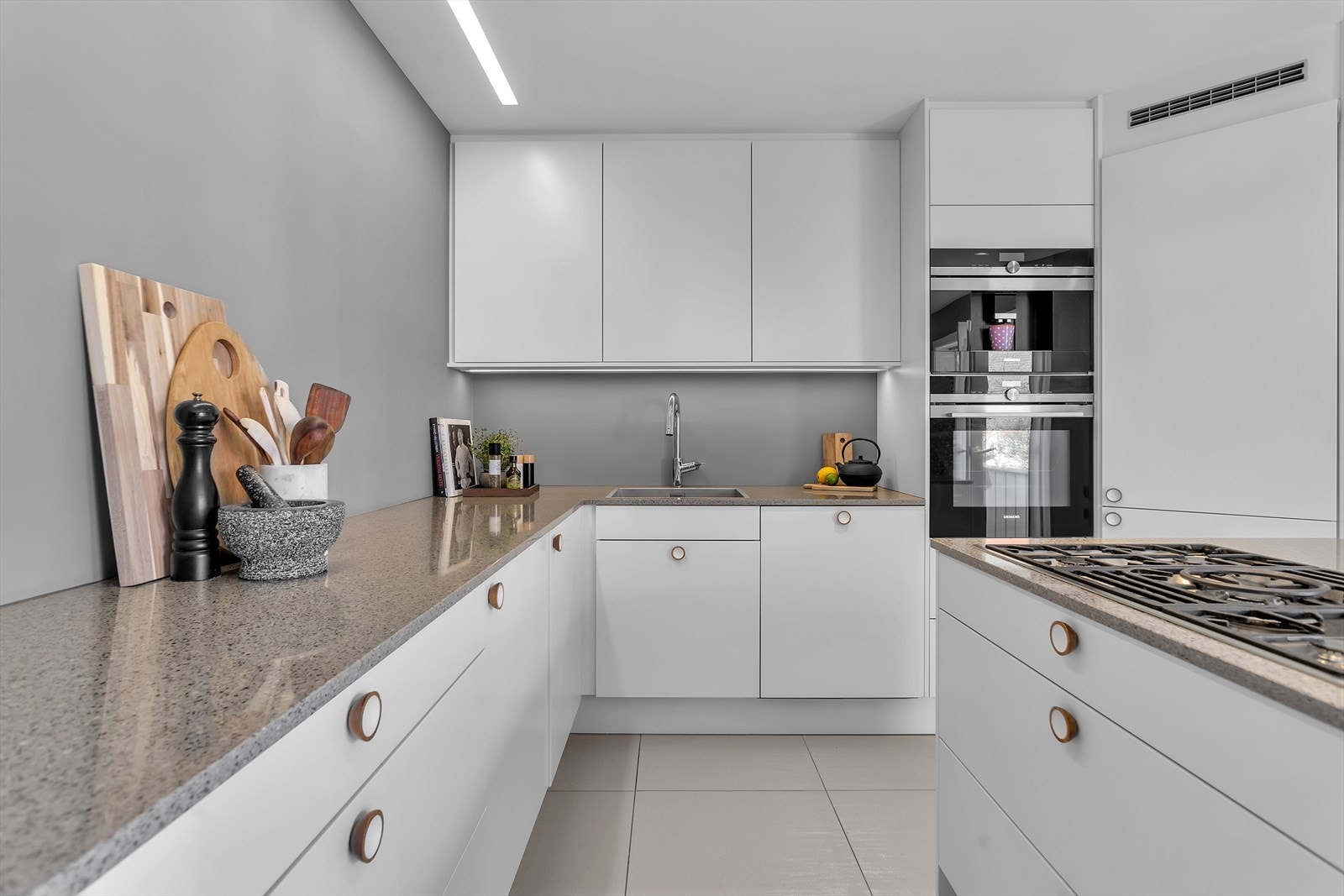 Kjøkkenet er et moderne og gjennomført kvalitetsrom med innredning fra Sørlandskjøkken, levert med solide løsninger og en eksklusiv steinbenkeplate fra Silestone. Her er det lagt til rette for at matlaging ikke bare er en nødvendighet, men også en glede. Galleribilde