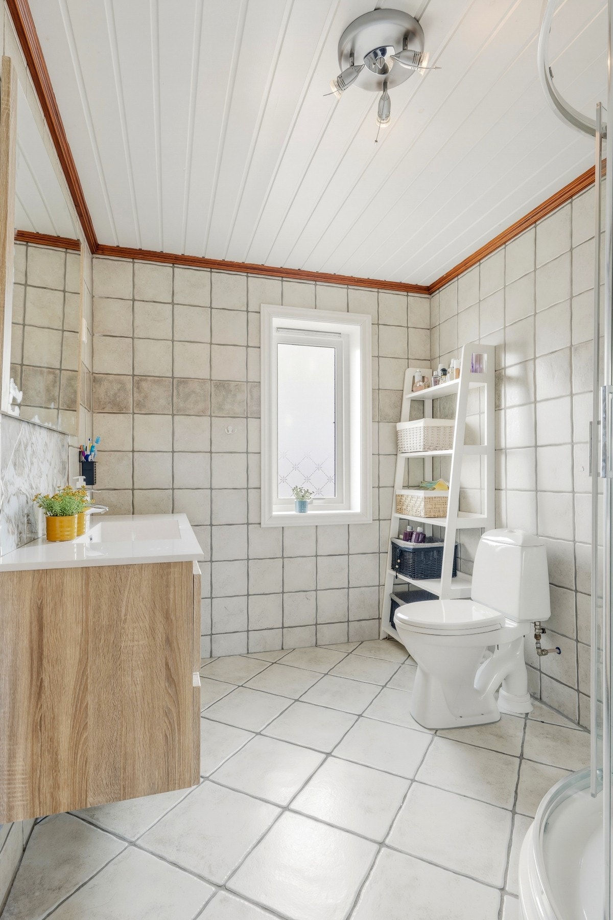 Badet i 2.etasje er helfliset, innredet med toalett, gulvvarme og dusjkabinett. En heldekkende servant har lyse skuffer og matchende speil. Galleribilde
