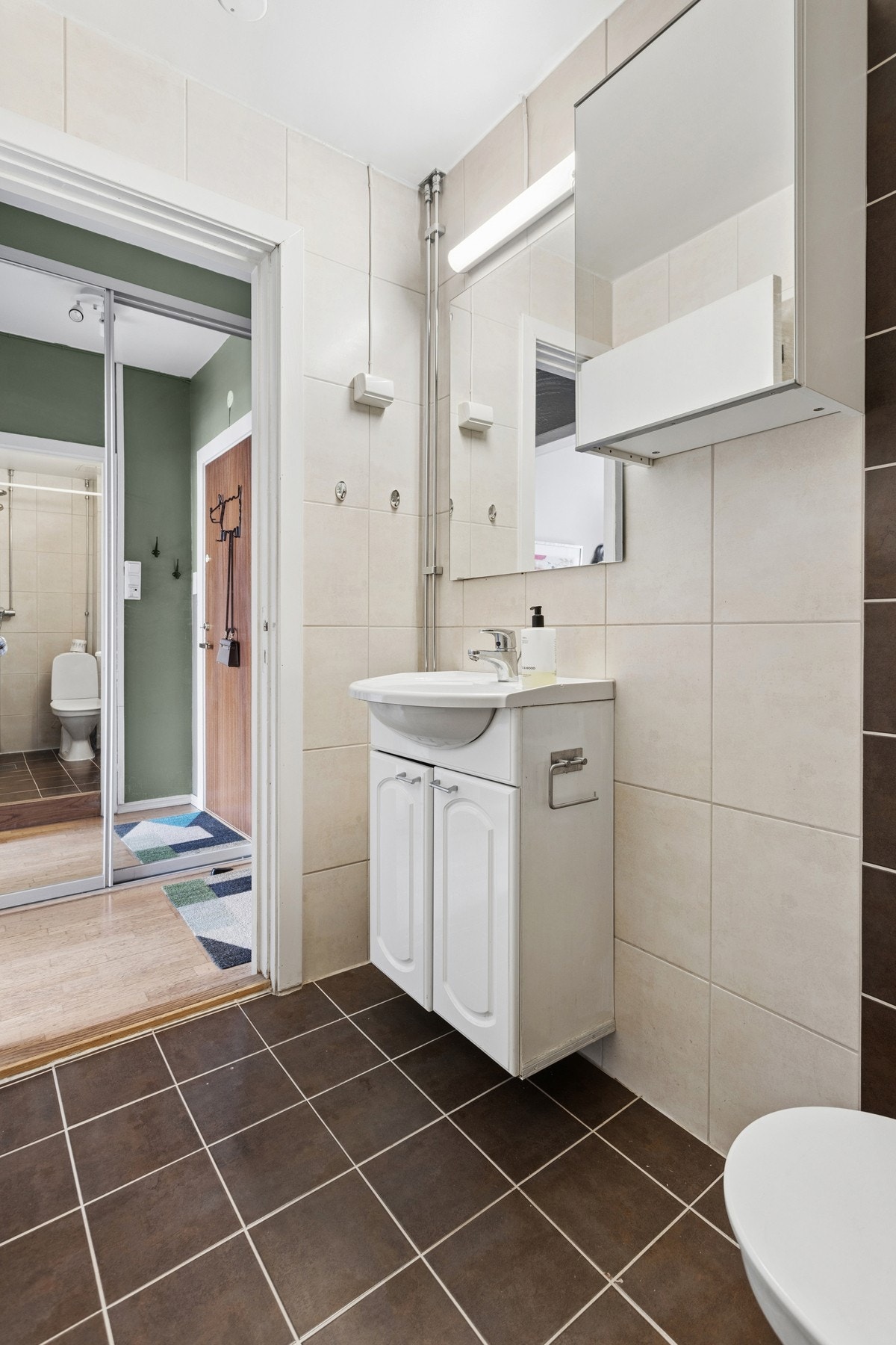 Badet er innredet med vegghengt servantinnredning med ovenpåliggende servant, speil med overlys, dusjhjørne samt gulvstående toalett. Galleribilde