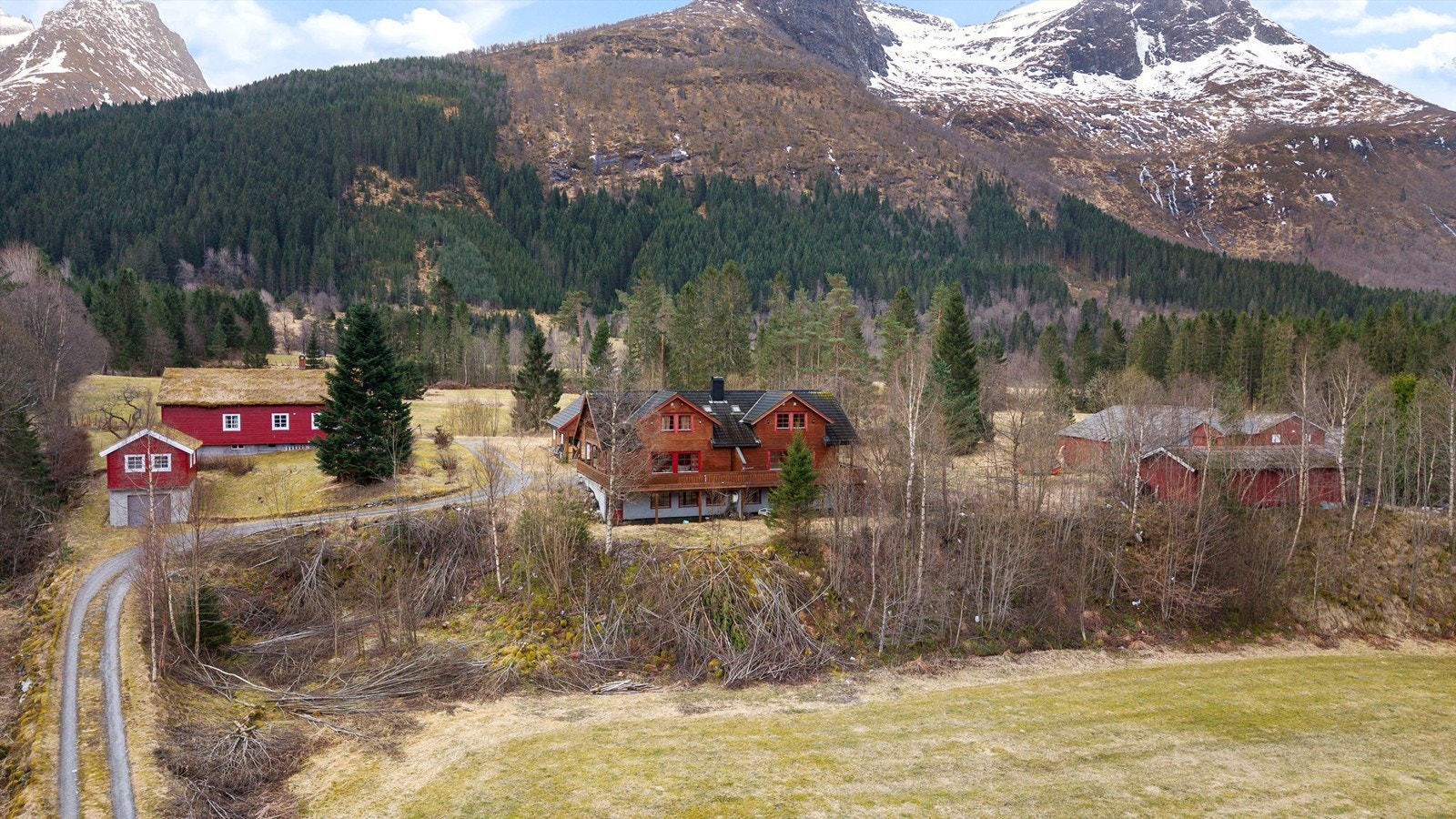 Eiendommen ligger fritt til med storslått natur og fjellandskapet i Sunnmørsalpene som nærmeste nabo. Galleribilde