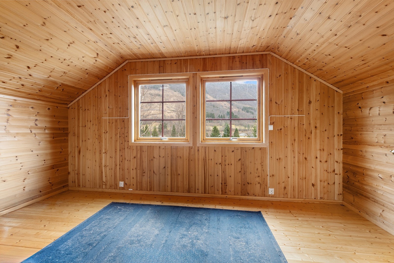 Det andre soverommet i loftsetasjen har godt med plass og overflater i trepanel. Galleribilde