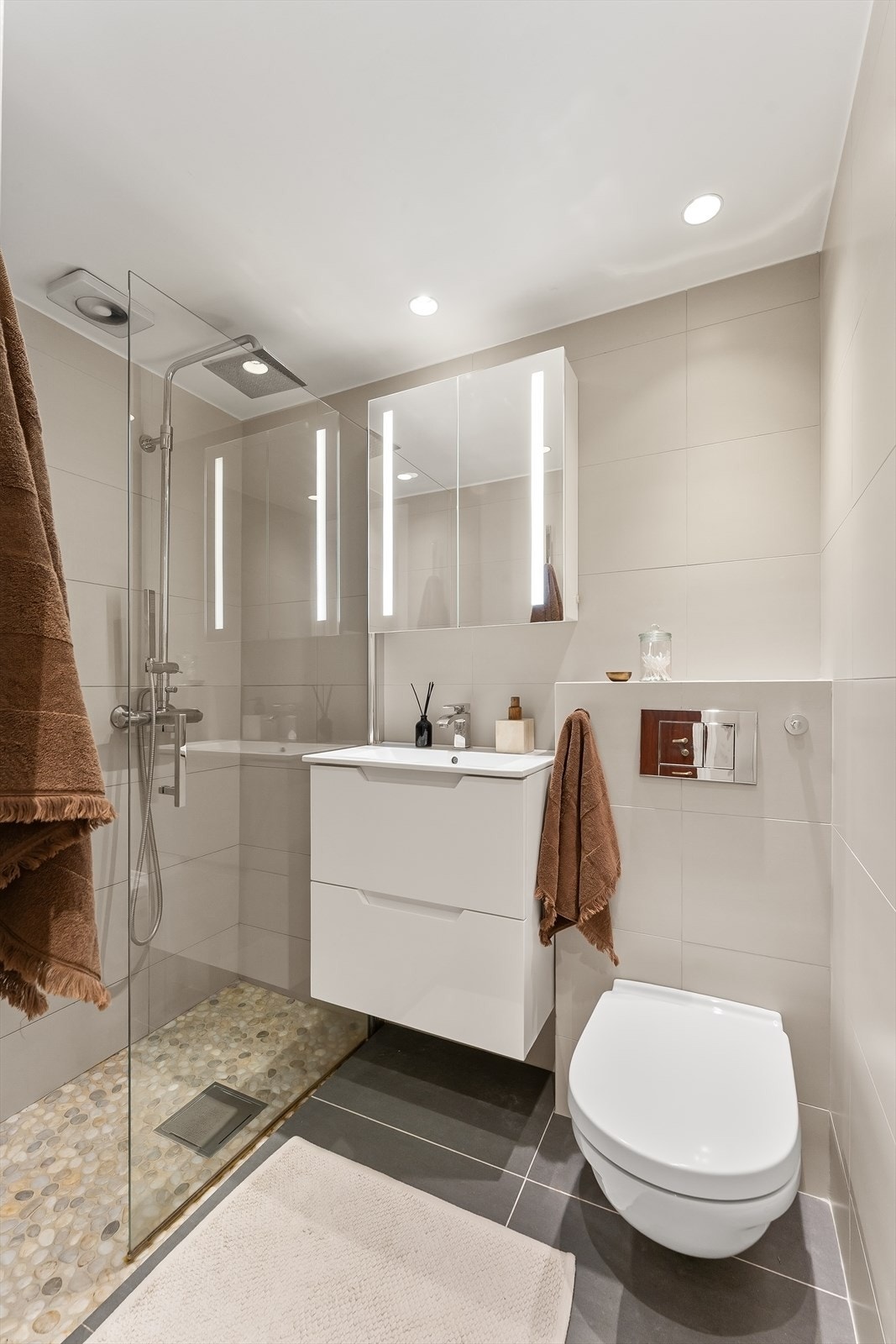 Pent og stilrent baderom med en gjennomgående god standard. Lyse flislagte vegger kombinert med mørkere gulvfliser gir et tidløst og elegant uttrykk. Galleribilde