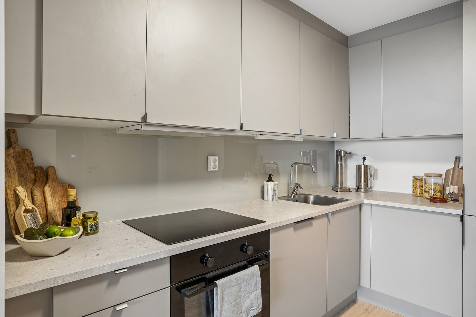 Moderne kjøkken med integrert stekeovn, vaskemaskin og kjøl/fryseskap. Galleribilde