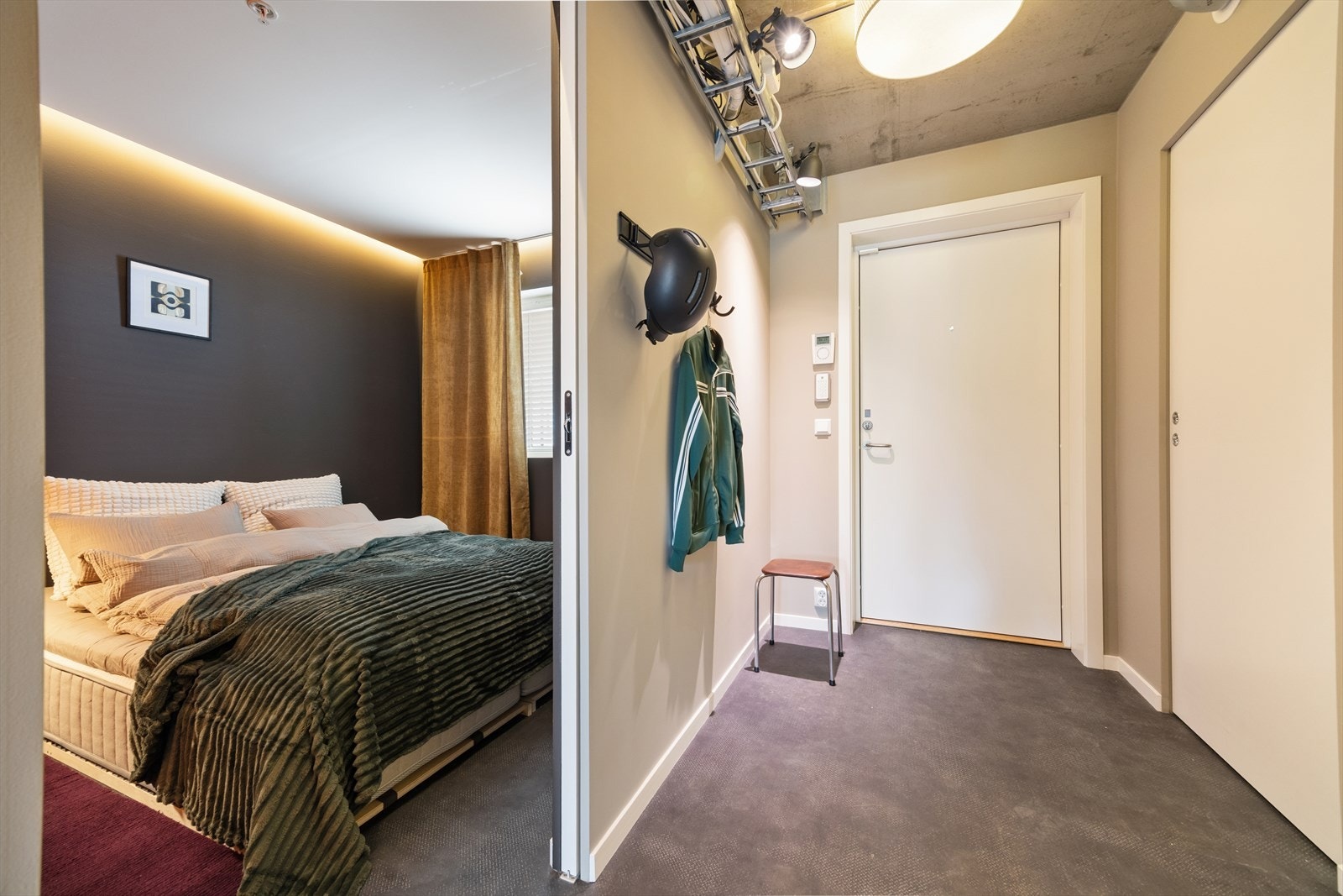 Industri-inspirert design med åpne kabelgater og ingen innboksing av ventilasjonsrør i gang/entre og kjøkken. Det er også universalløsning i leiligheten. Galleribilde