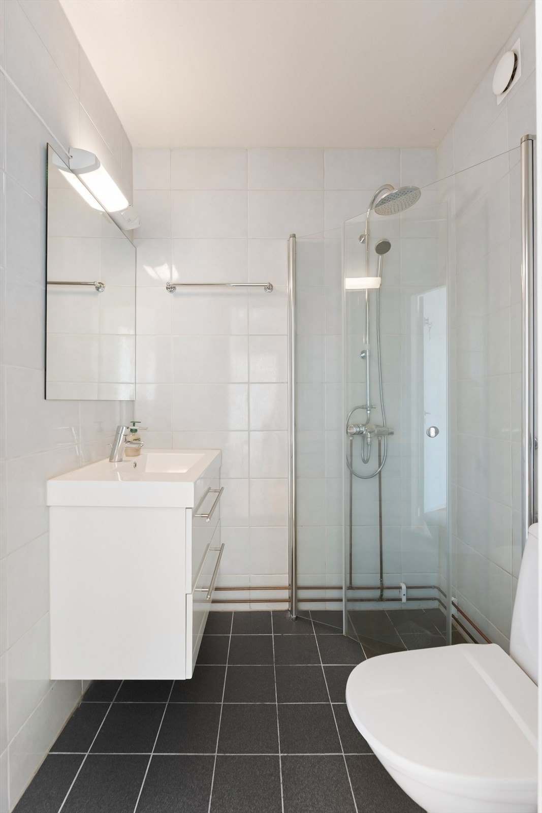 Badet er utstyrt med gulvstående toalett og har naturlig avtrekksventil på vegg. Galleribilde