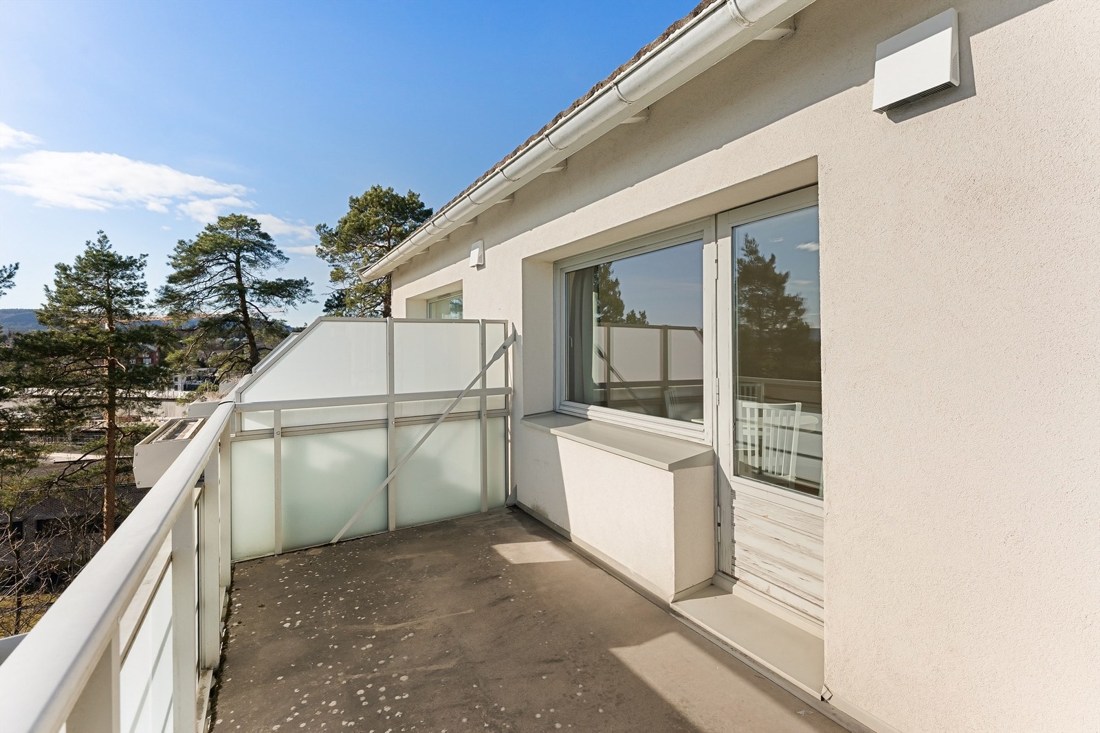 Balkongen har betongdekke og rekkverk av metall og glass. Galleribilde