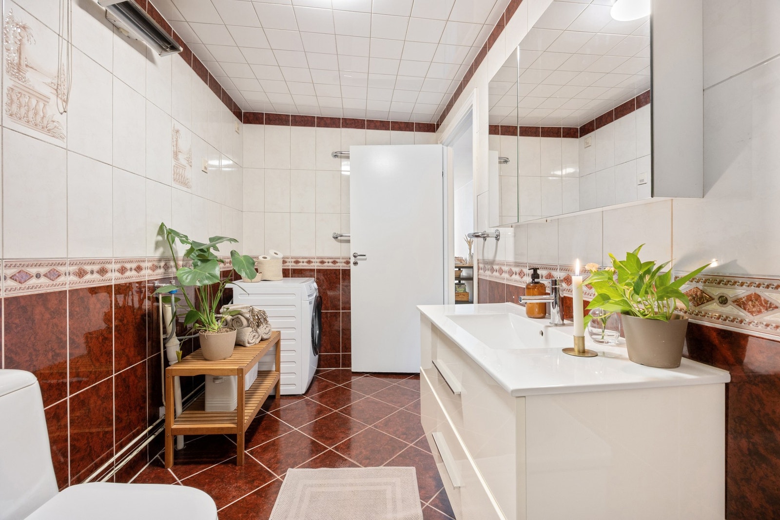 Badet har vegghengt servantinnredning med ovenpåliggende servant og armatur fra 2019. Speilskap på vegg. Galleribilde