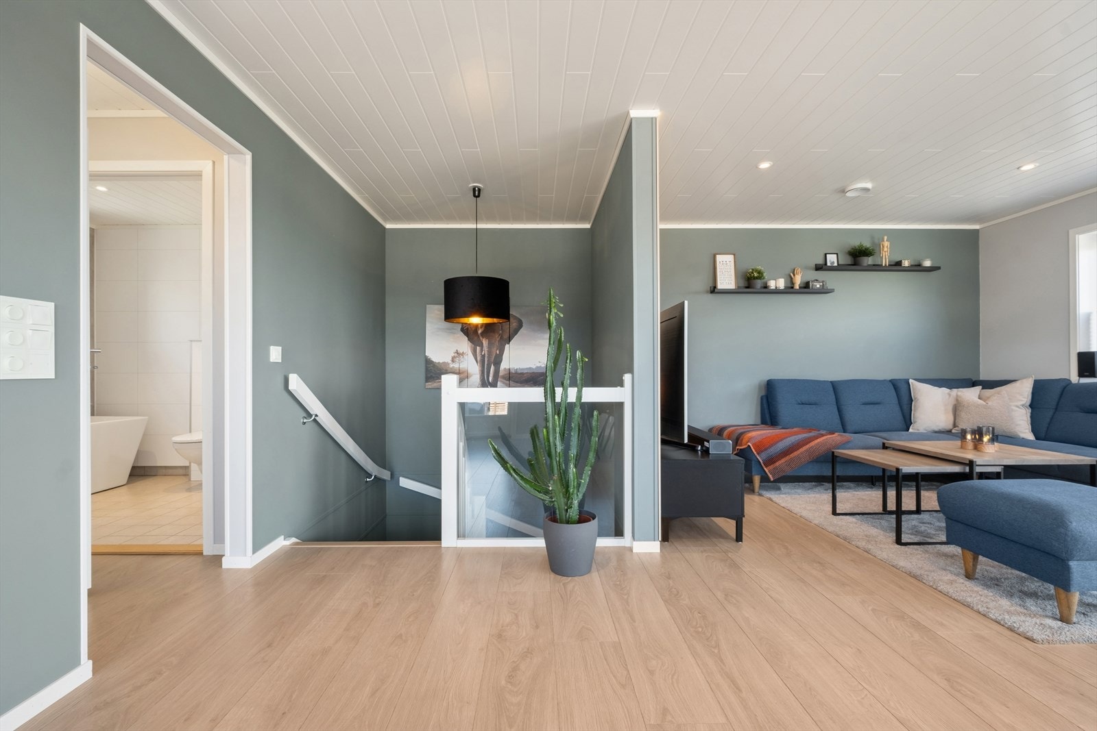 Trappen i malt tre med trinn av eik leder opp til den åpne og luftige stuen i andre etasje. Galleribilde