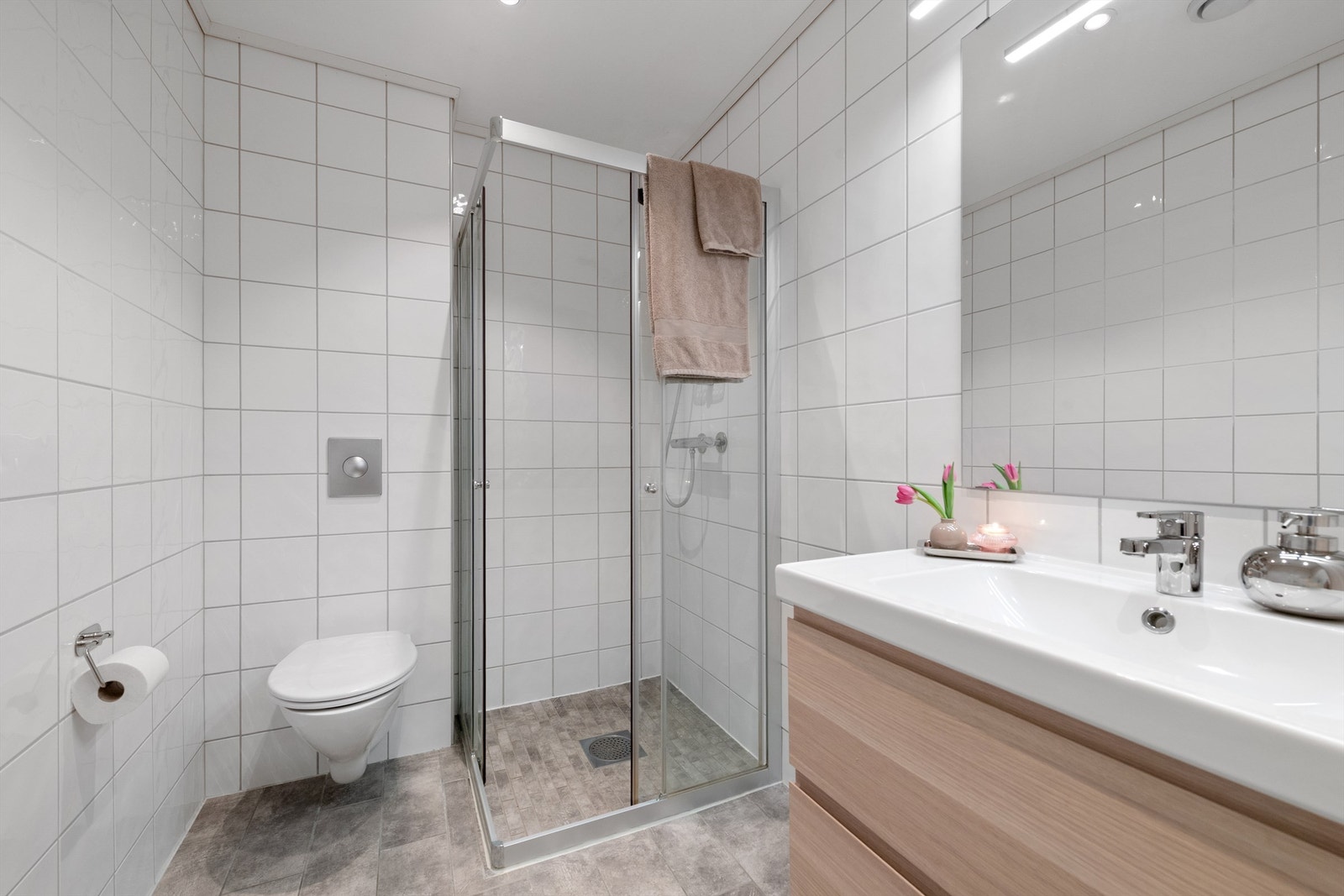Badet i første etasje har flislagt gulv med gulvvarme, dusjhjørne og vegghengt toalett. Galleribilde