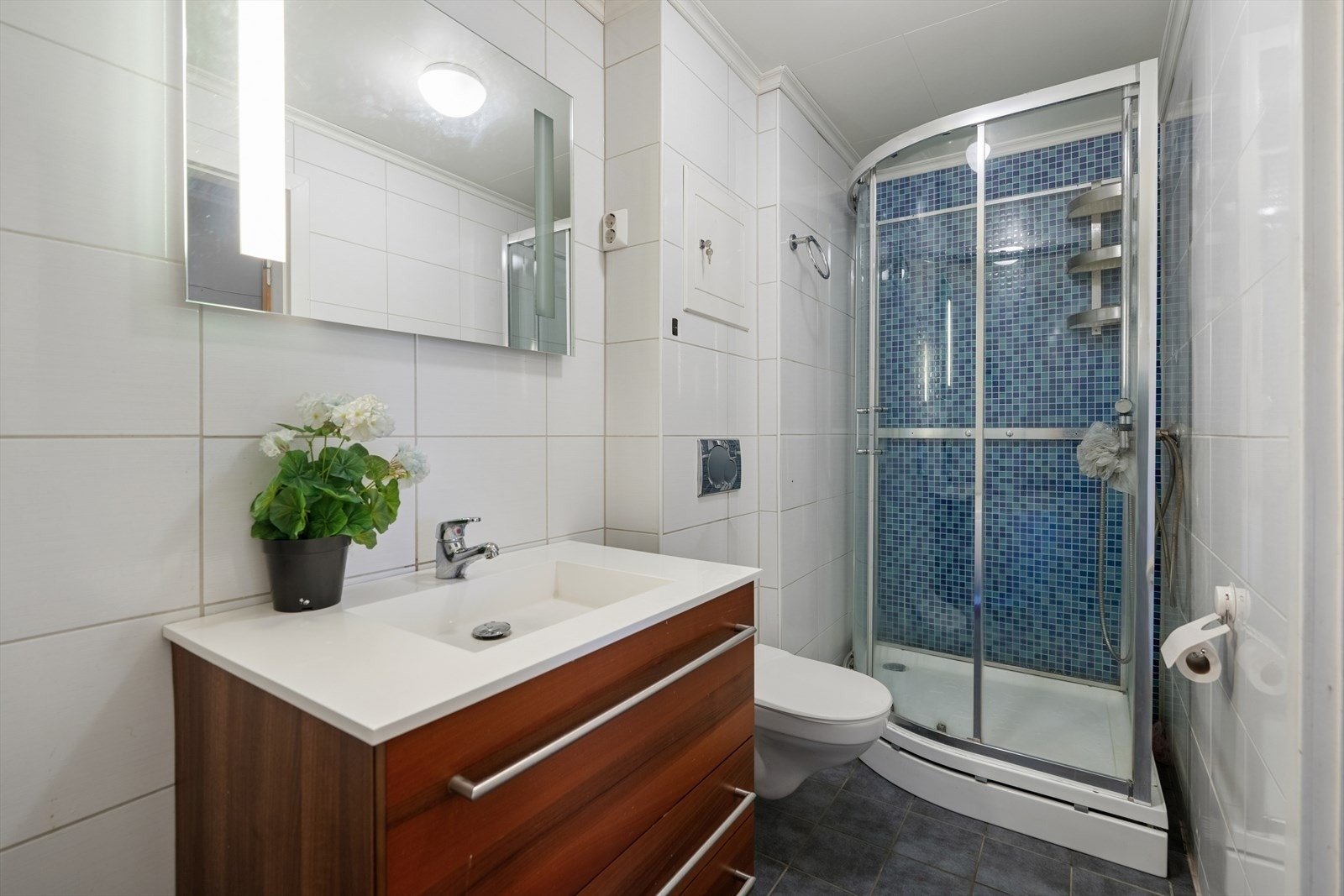 I tillegg til badekar har badet dusjkabinett, vegghengt toalett og en baderomsinnredning med heldekkende servant. Galleribilde