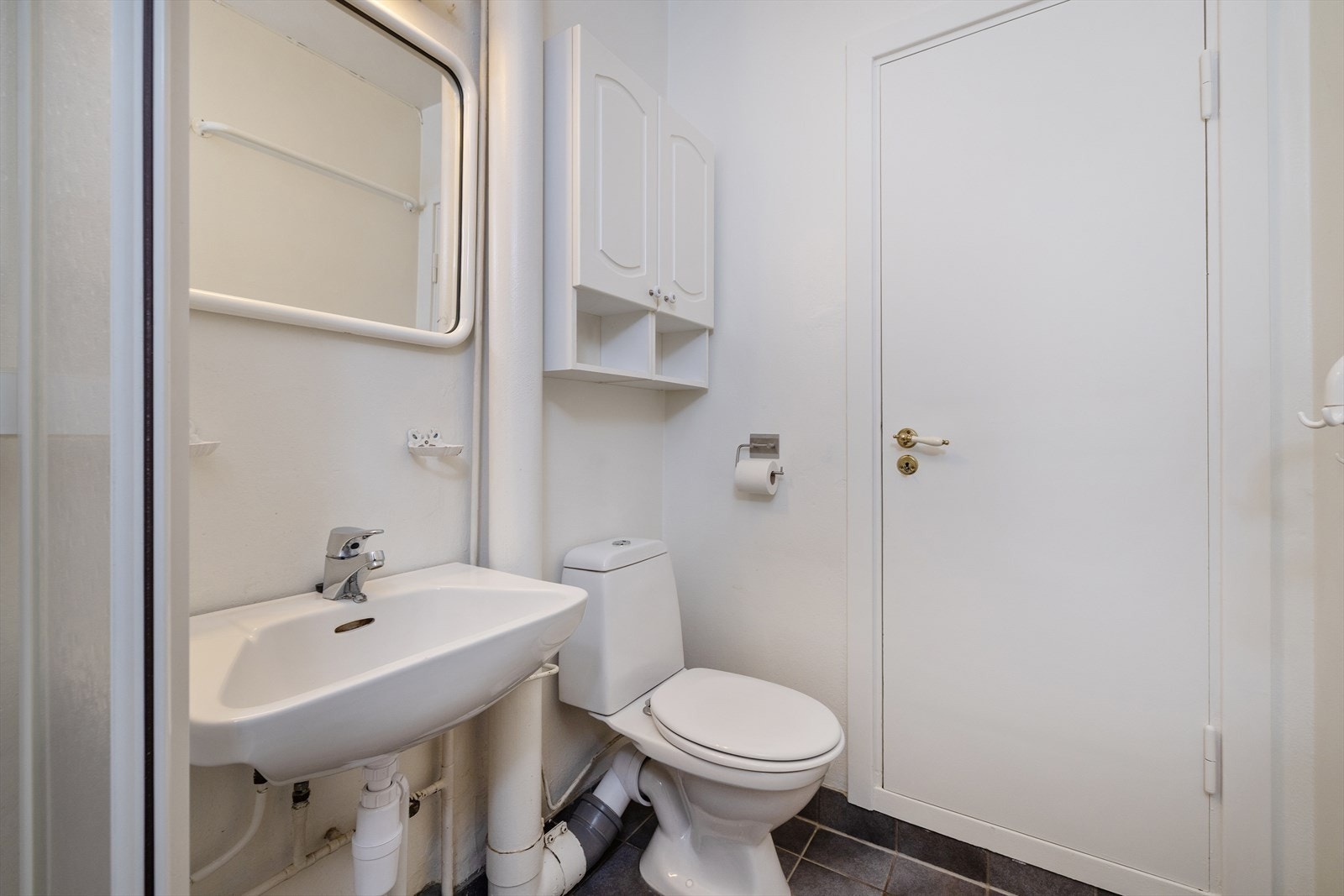 Badet er utstyrt med toalett, servant med speil og overskap. Galleribilde