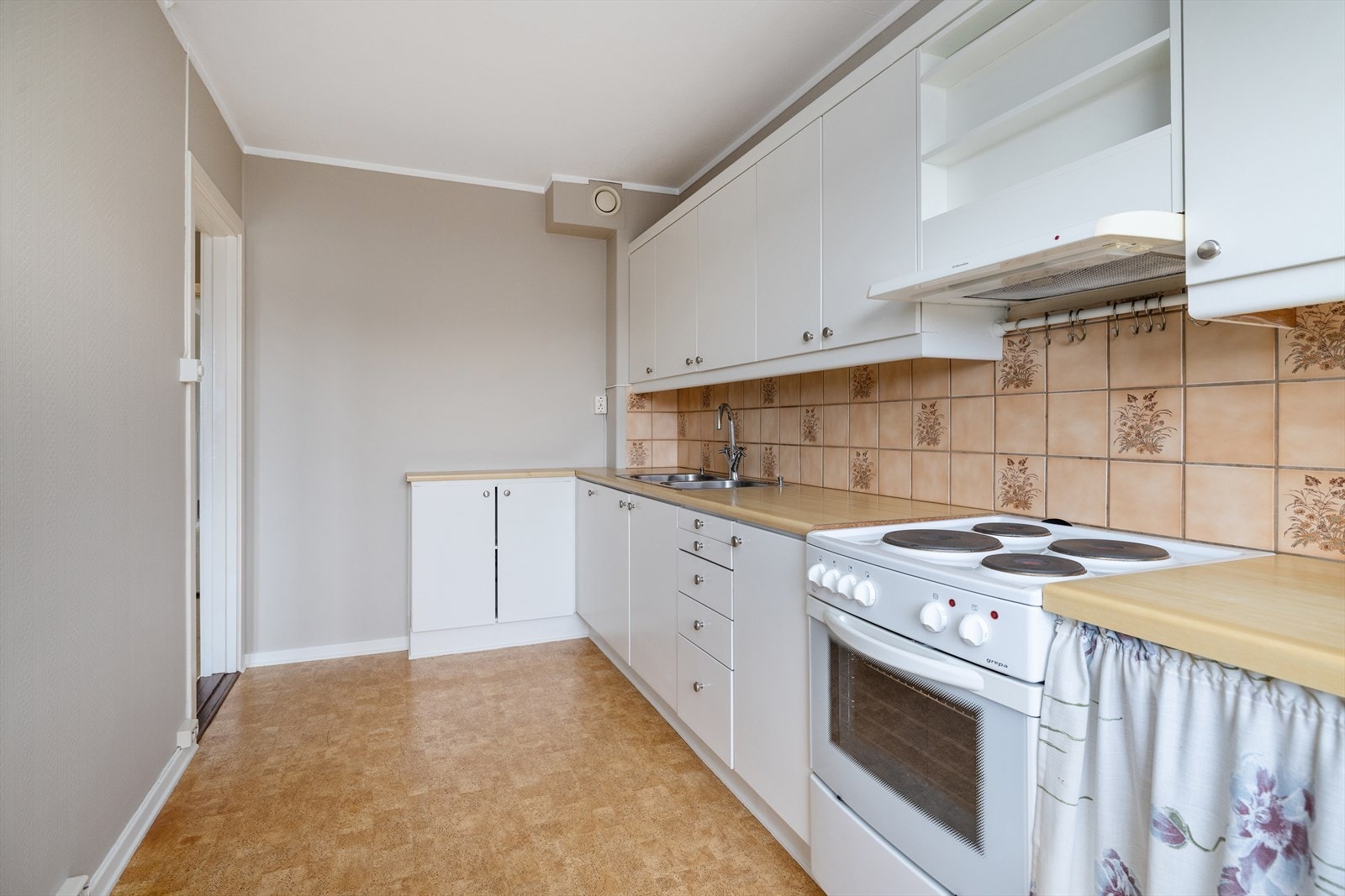 Kjøkkeninnredningen har glatte, hvite fronter og laminat benkeplate. Galleribilde
