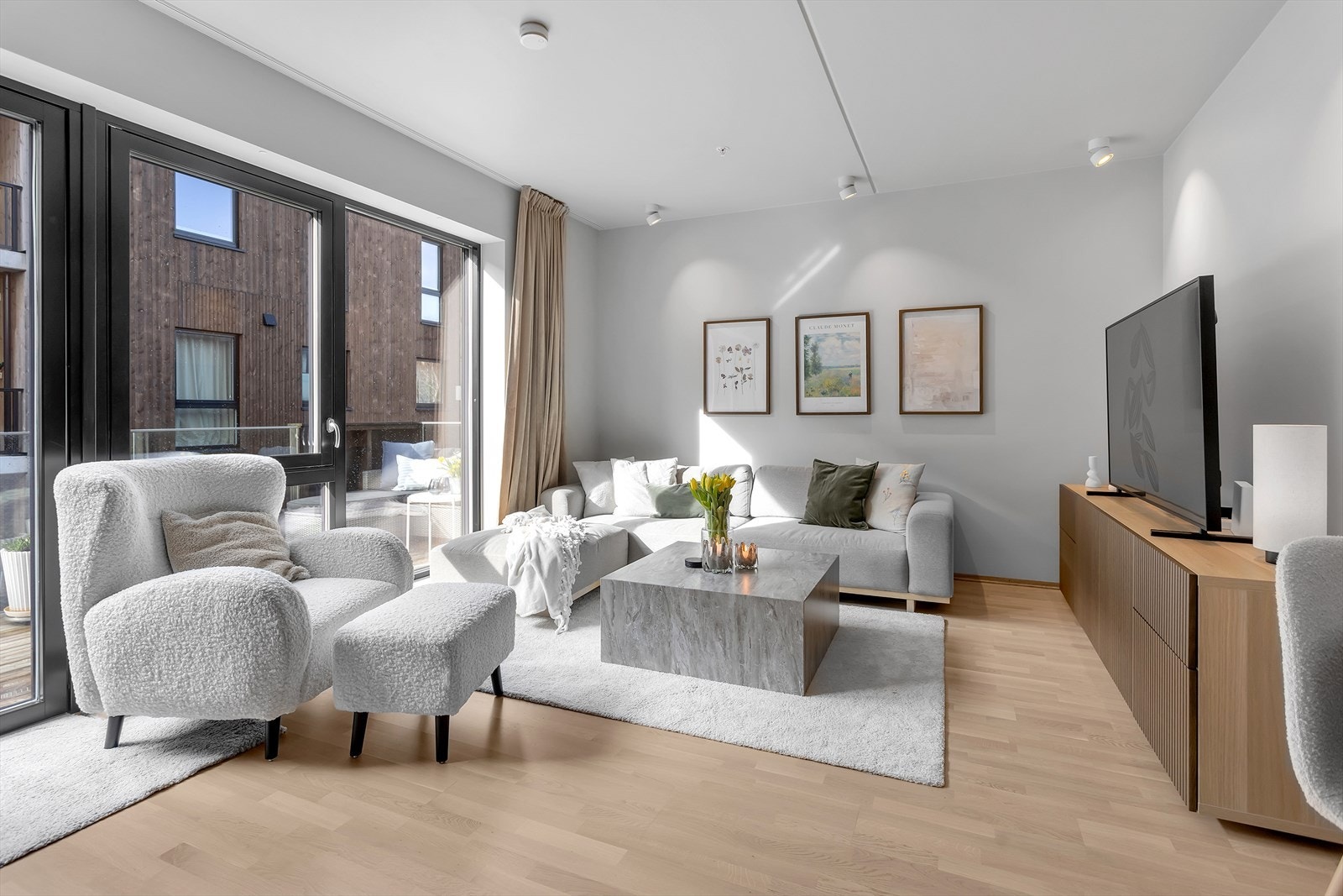 Lys og romslig stue med moderne fargevalg. Store vindusflater sørger for rikelig med naturlig lys, mens downlights i taket forsterker den moderne følelsen i rommet. Galleribilde