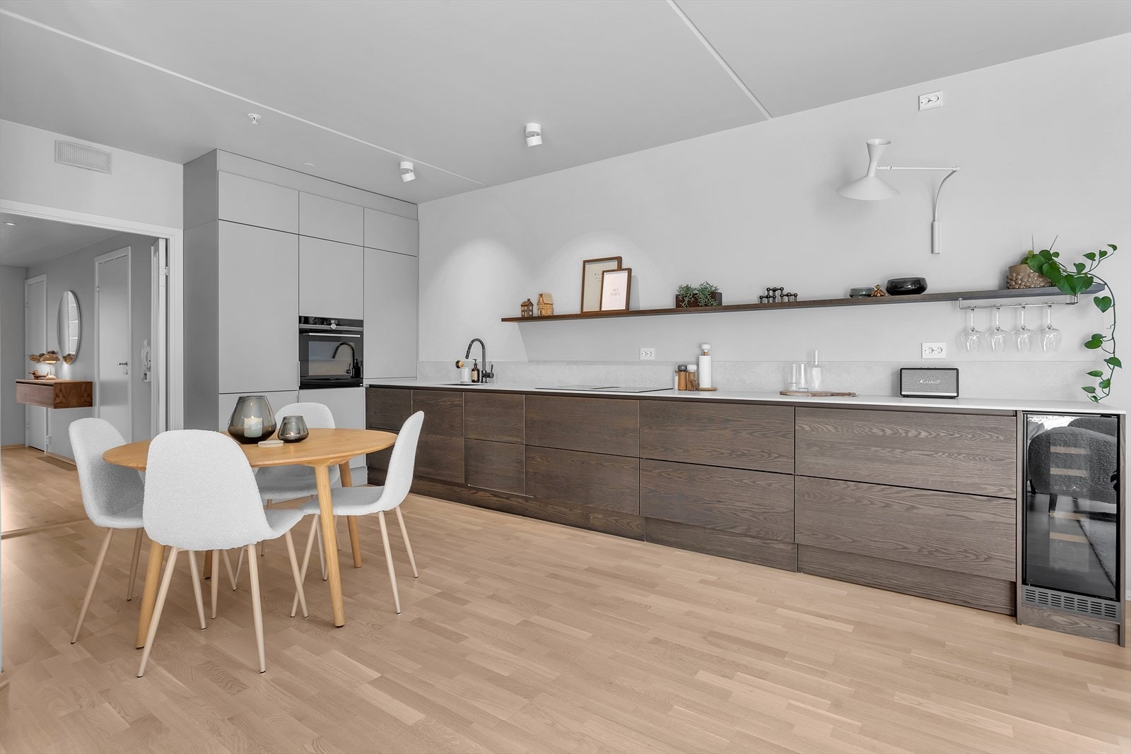 Kjøkkenet byr på moderne løsninger med integrerte hvitevarer, inkludert platetopp med innebygd ventilator, stekeovn i ergonomisk ståhøyde, kjøle-/fryseskap, oppvaskmaskin og vinskap. Galleribilde