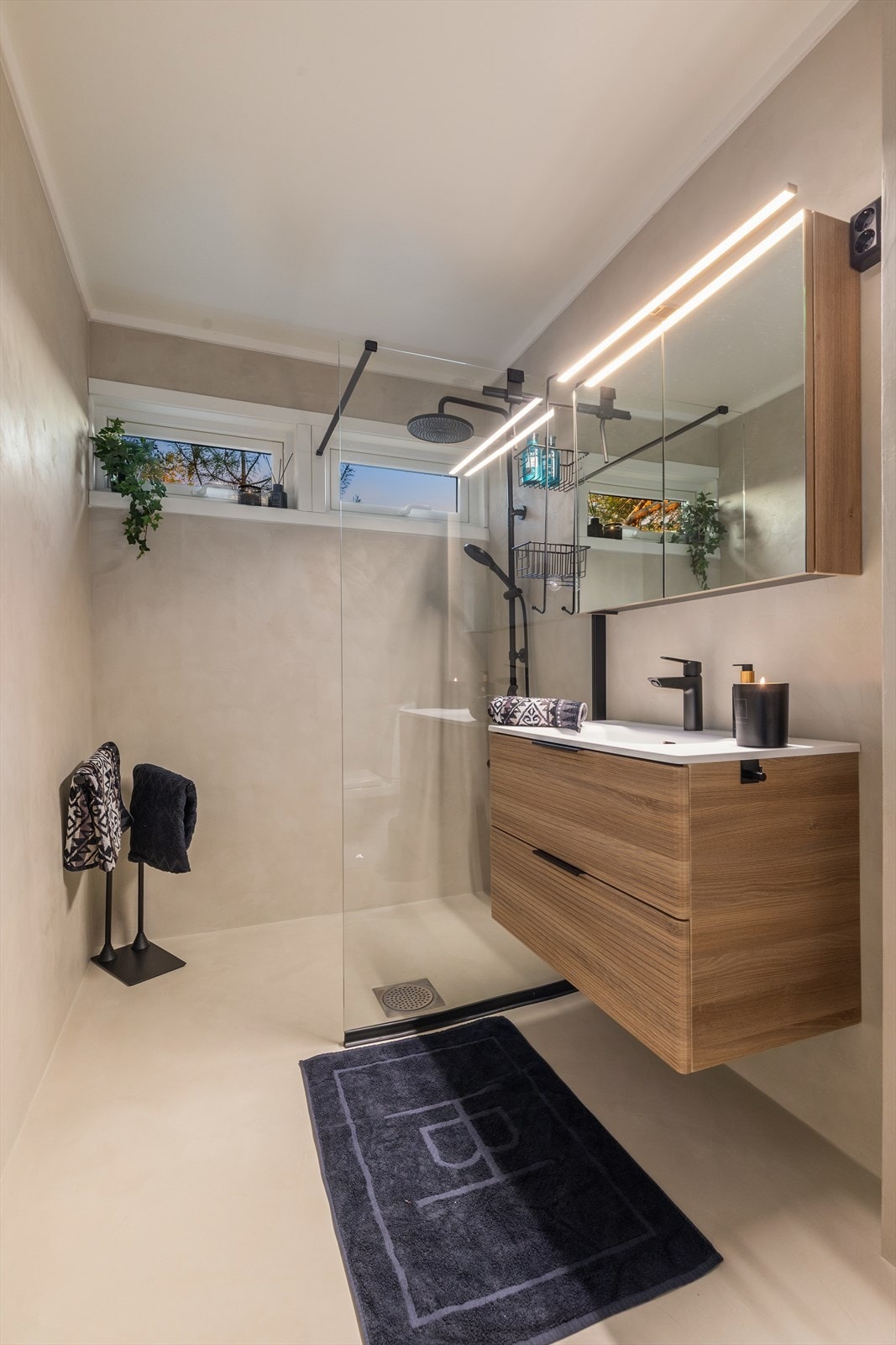 Badet er videre utstyrt med moderne innredning med servant, underskap, speilskap, dusjnisje m/regndusj og toalett Galleribilde