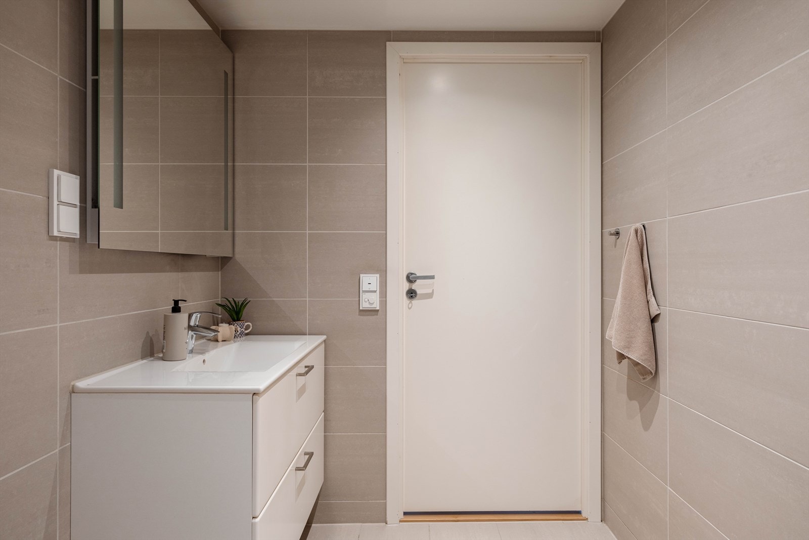 Badet er innredet med vegghengt toalett og servant. Fordelerskapet for rør-i-rør-systemet er plassert her. Galleribilde
