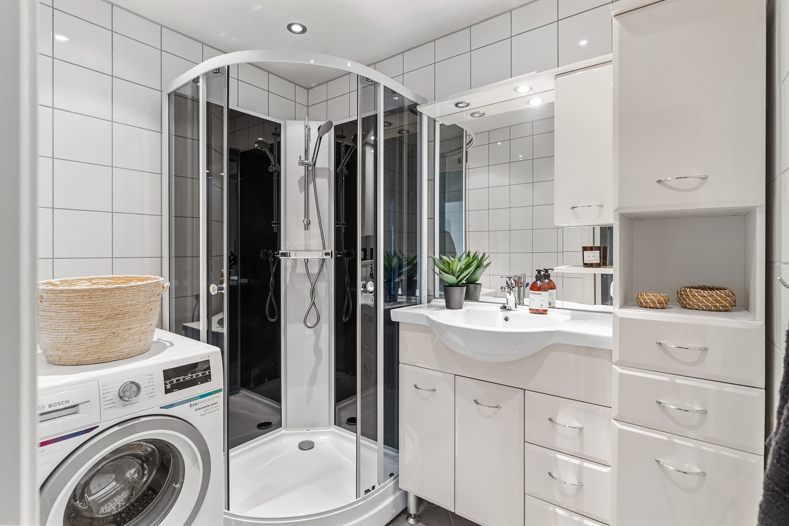 Badet har fliser på gulv og vegger samt gulvvarme. Innredningen består av servantskap, speil med belysning. Galleribilde