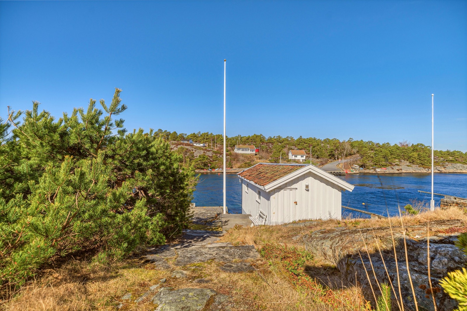 Idyllisk utsikt mot sjøen med egen brygge og naust, omkranset av vakker skjærgård. Galleribilde