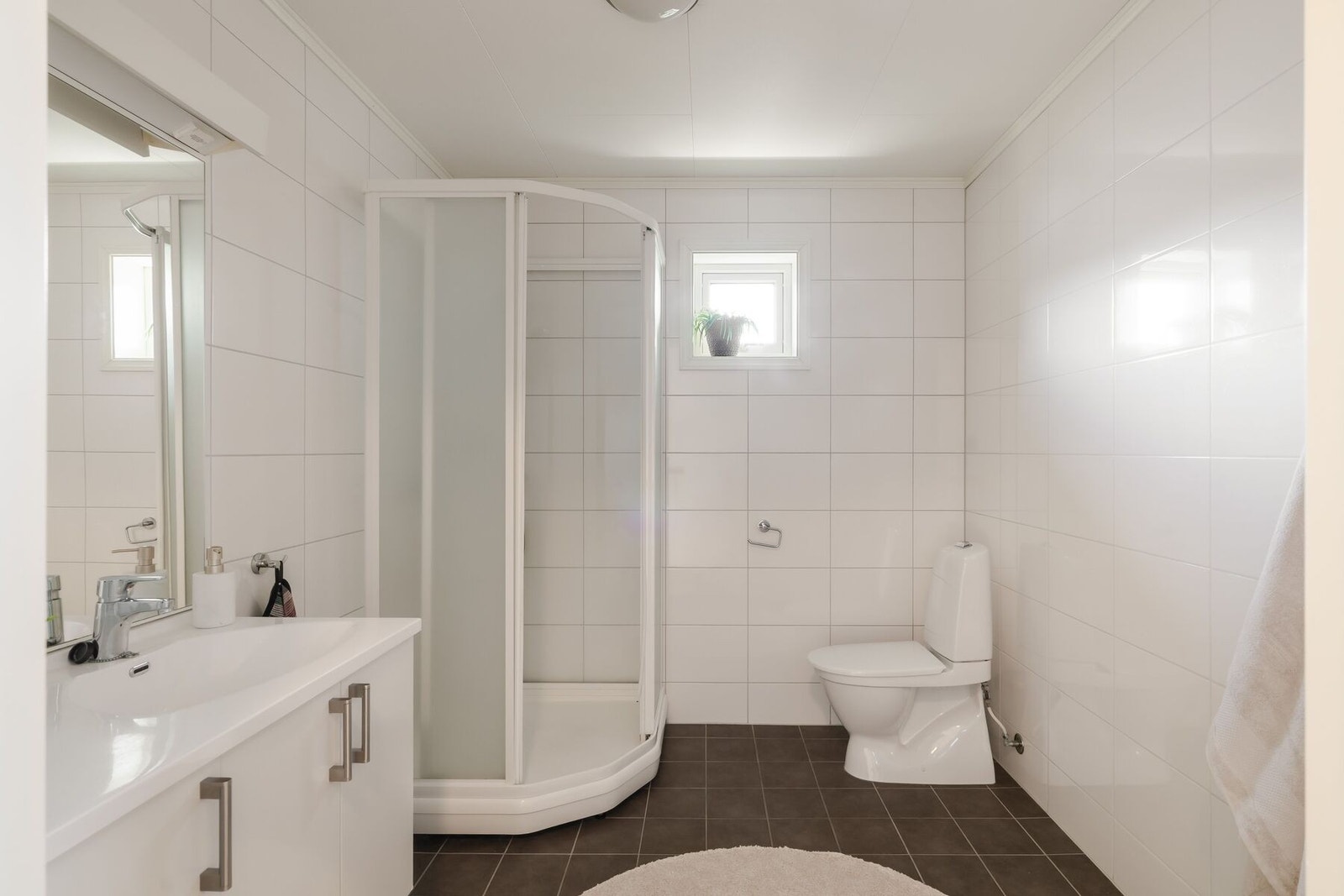 Badet er utstyrt med dusjkabinett, servantinnredning og gulvmontert toalett. Her ligger alt til rette for å få en god følelse av komfort i hverdagen. Galleribilde