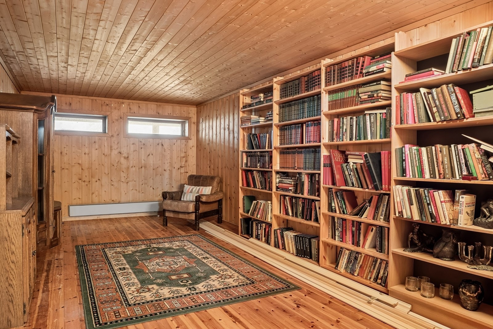 Stort, innreidd rom i kjellaren med tregolv og panel på vegger og i tak. Galleribilde