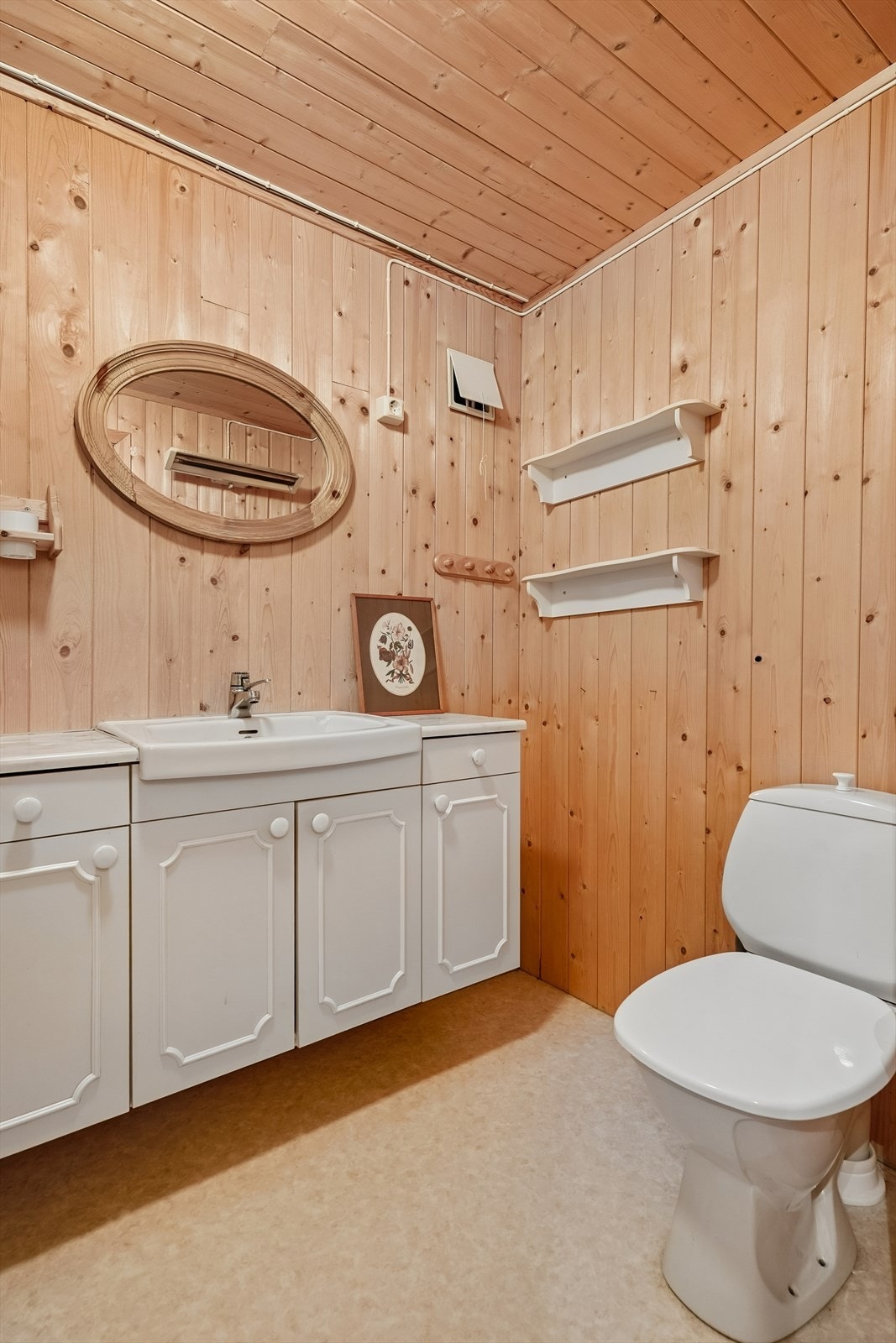Badet har belegg på golvet og panel på vegger og i tak. Galleribilde
