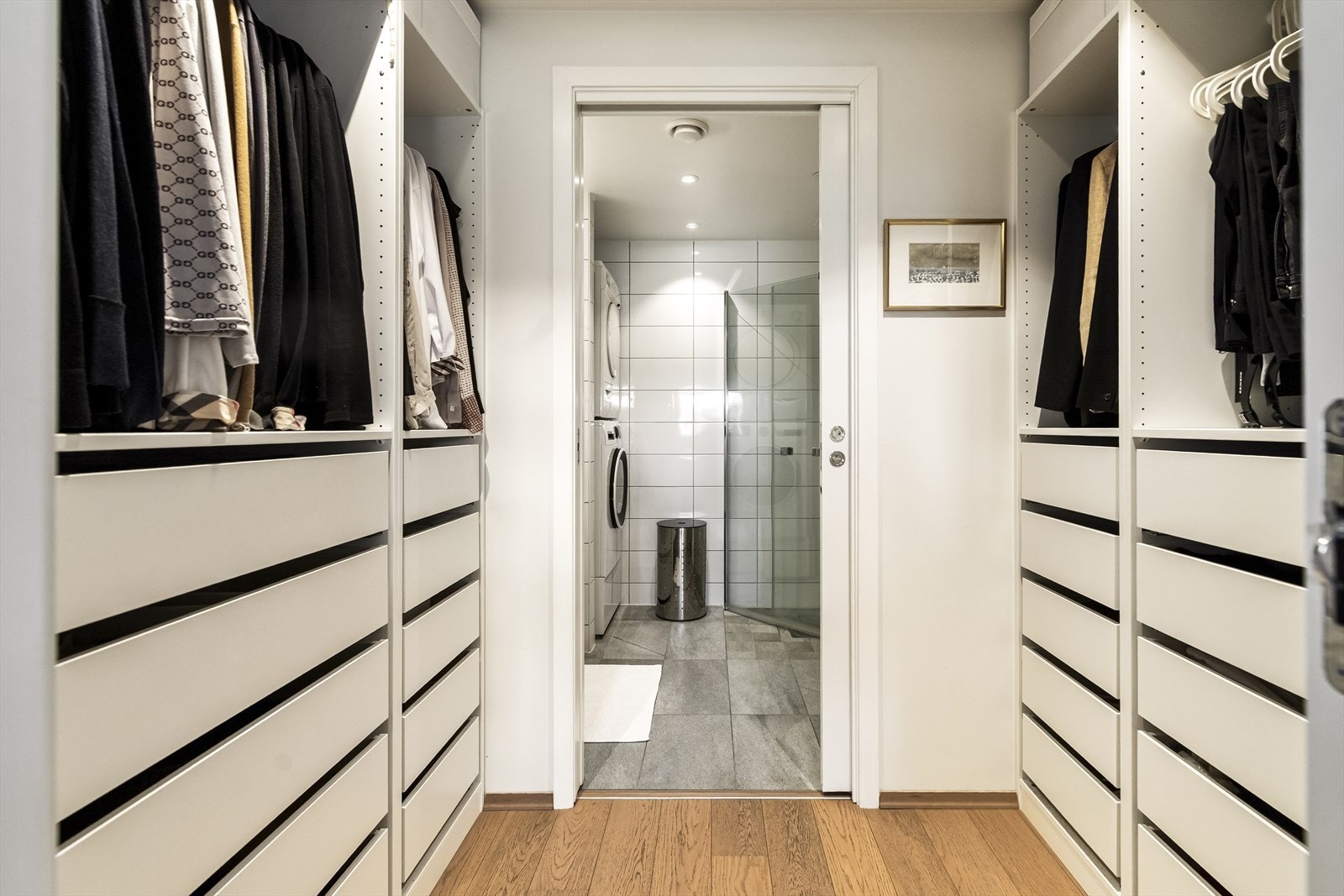 Praktisk og tiltalende garderoberom i moderne stil som har godt med oppbevaringsplass. Man kommer så inn på hovedbadet som er et rom å bli glad i. Galleribilde