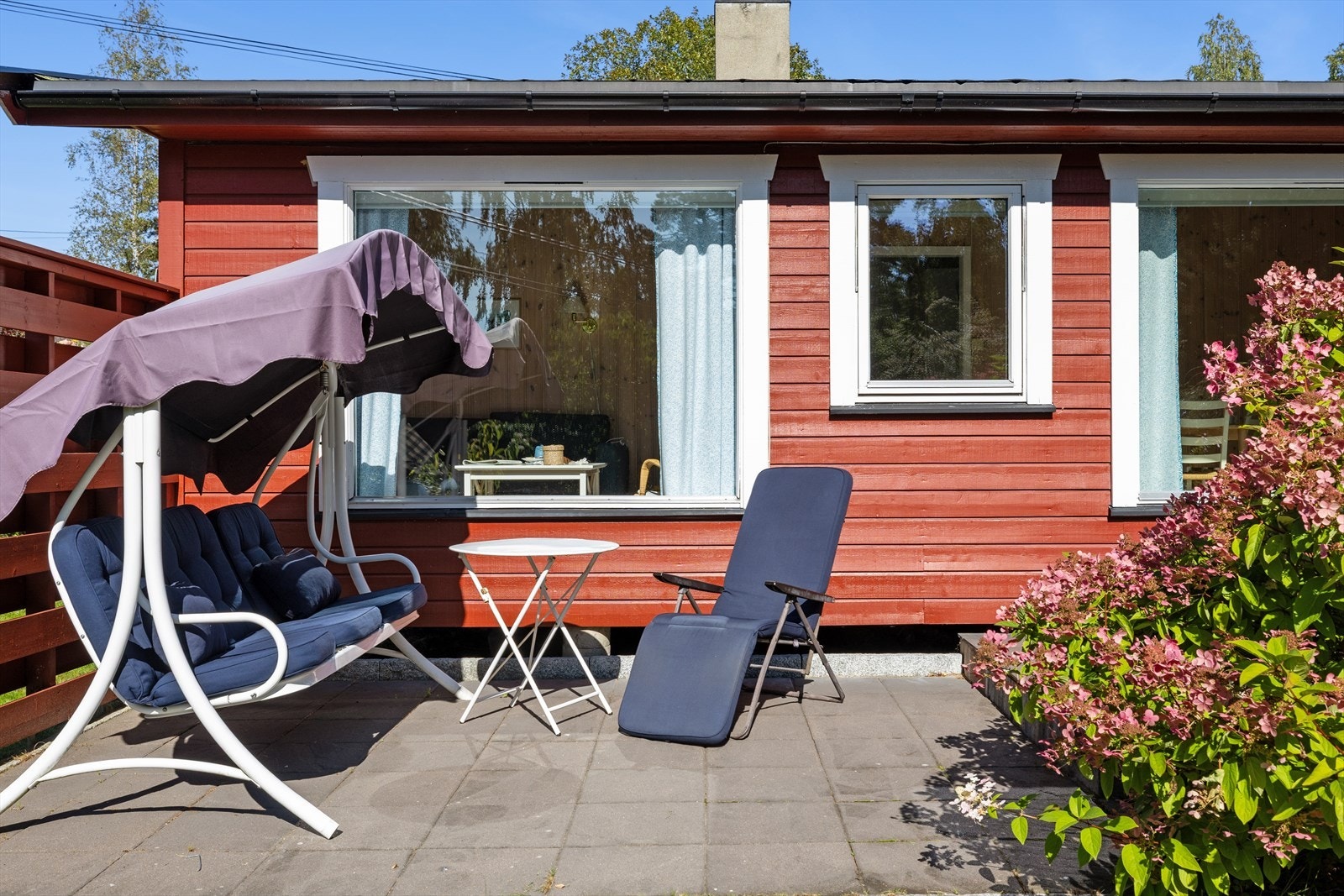 Uteplassen foran stuen er solrik og svært trivelig, med en stor, hellelagt terrasse som gir gode soner for både avslapning og sosiale sammenkomster. Galleribilde