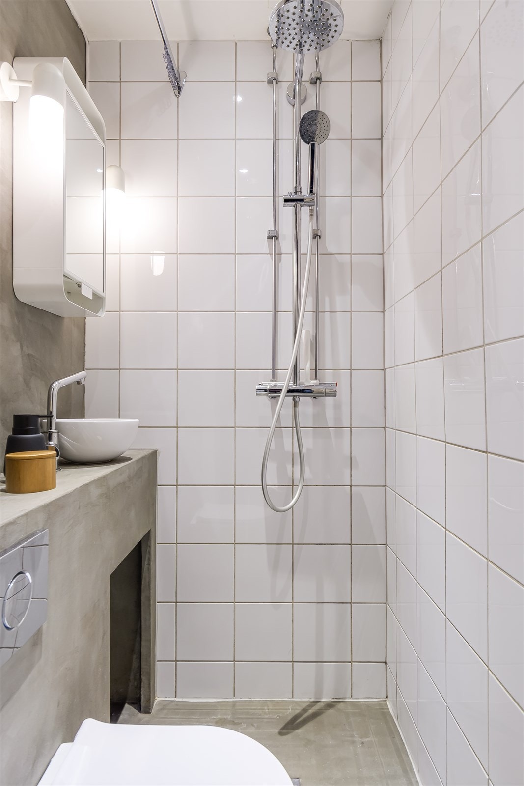 Badet er utført med fliser på vegg og mikrosement på gulv og veggen ved vasken. Galleribilde