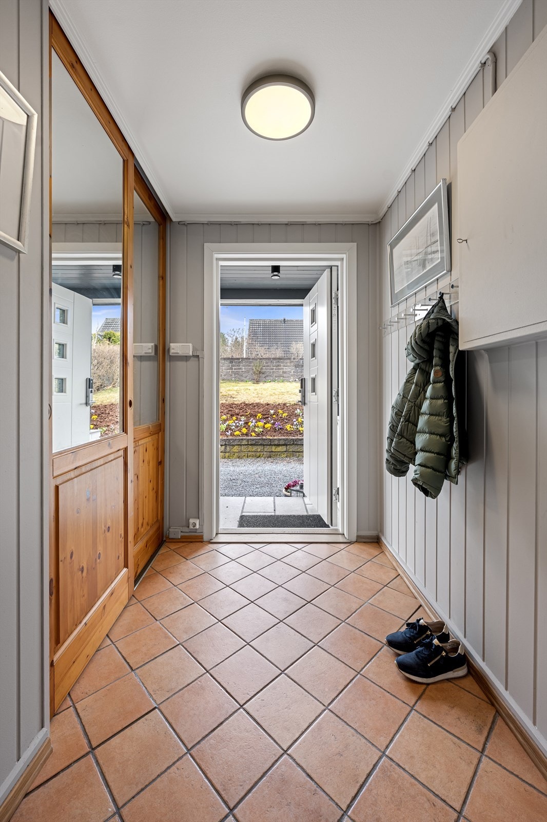 Velkommen inn. Entreen ligger i boligens 1.etasje. Her er det praktisk innredet med fliser på gulvet med varmekabler under, samt stor garderobeløsning med skyvedører. Galleribilde