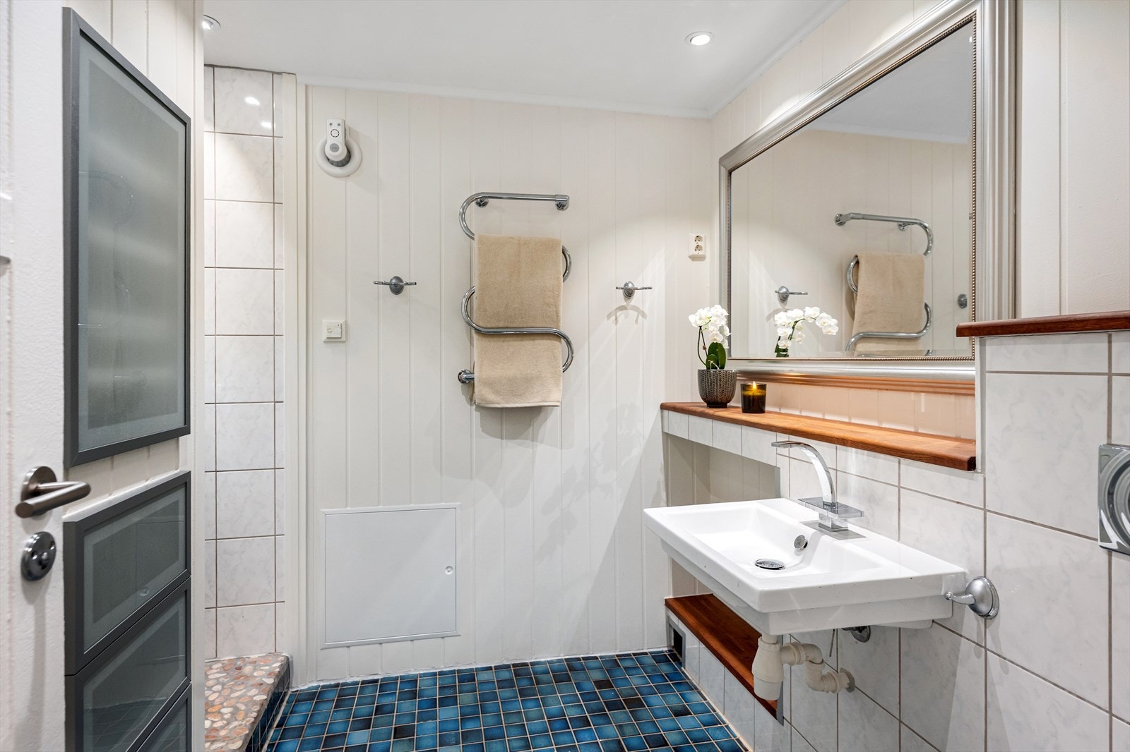 Badet i underetasjen er praktisk innredet med egen dusjnisje, vegghengt servant og toalett. Galleribilde