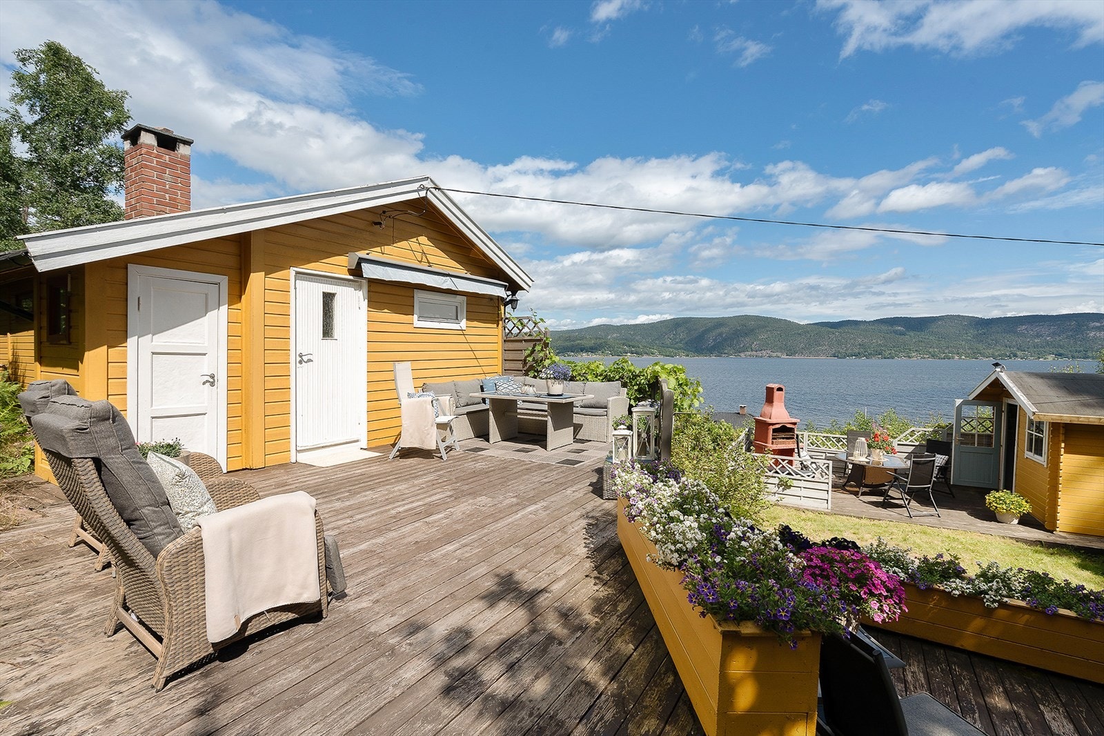 En sjarmerende og idyllisk hytte med strålende utsikt ut mot fjorden og kun et steinkast unna fjorden og badestrand. Galleribilde