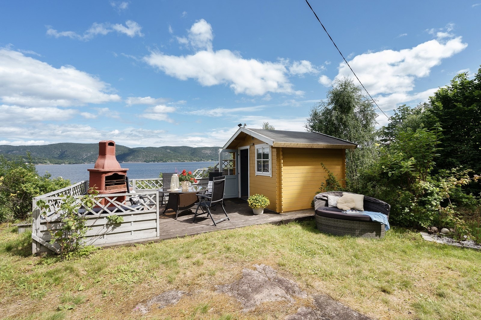 På hytta kan en nyte solskinnet og se på båtene og nyte den flotte sommer-atmosfæren. Galleribilde