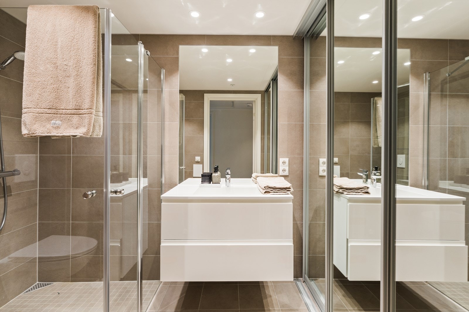 Badet er moderne og helfliset, med en stilren utforming og gode materialvalg. Vannbåren varme i gulvet sørger for høy komfort året rundt. Galleribilde