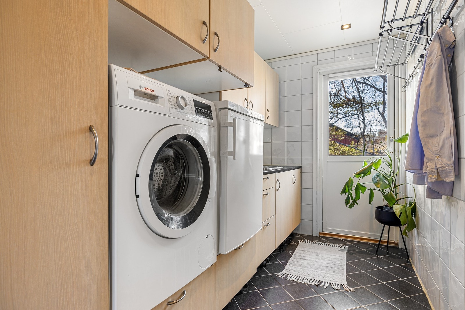 Svært praktisk vaskerom med egen inngang fra hagen og innredning med både god benk- og oppbevaringsplass. Galleribilde