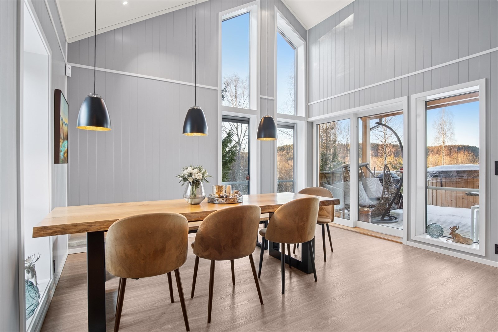 Spisestuen har svært god takhøyde, og adkomst til terrassen via skyvedører Galleribilde