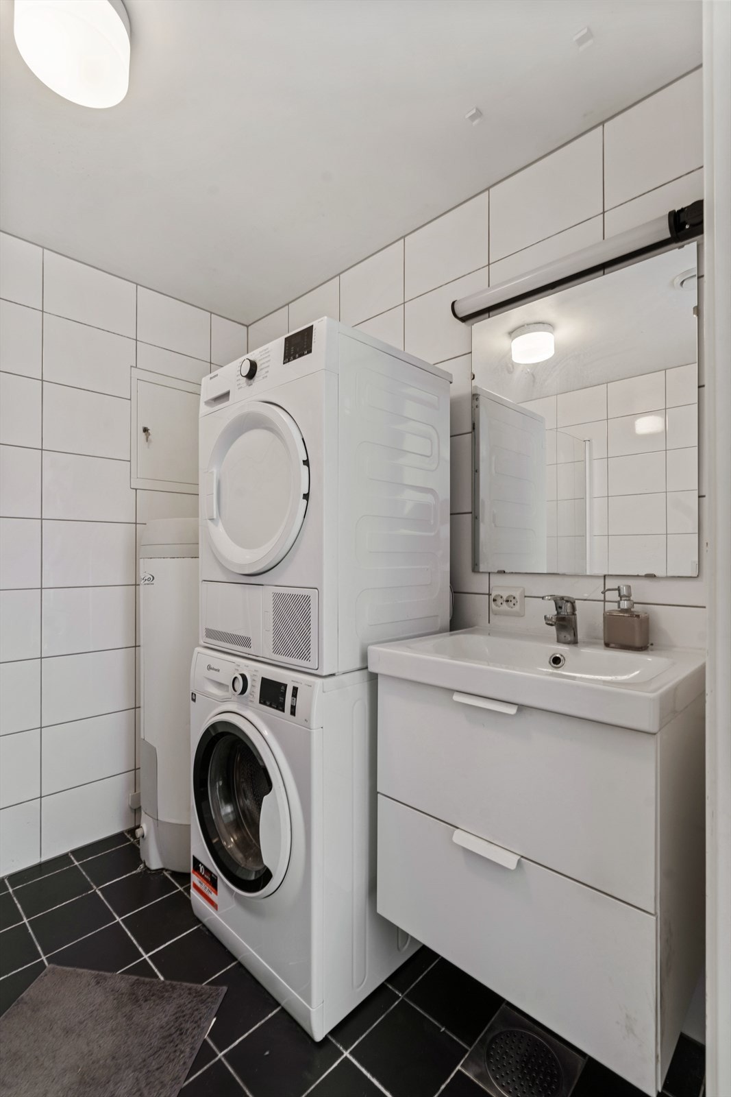 Her er det også opplegg for vaskemaskin og tørketrommel, med praktisk plassering ved siden av servantinnredningen. Galleribilde