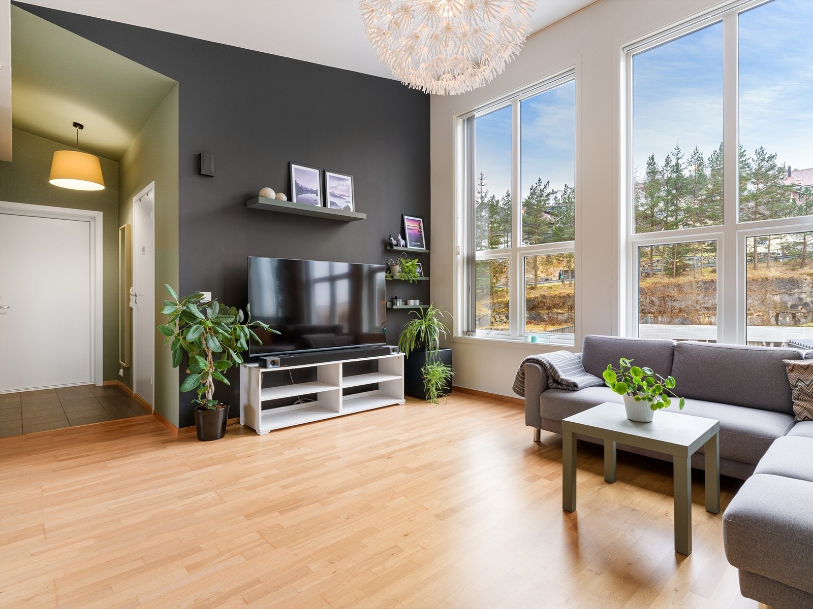Store vinduer slipper inn mye lys i stua. Galleribilde