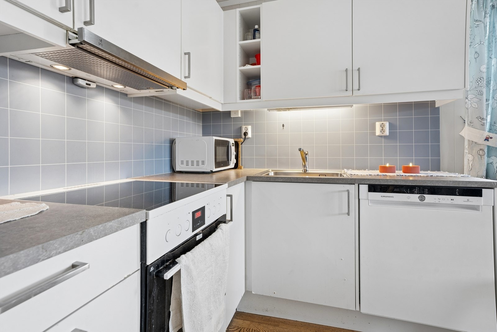 Over benkeplaten er det montert belysning og plater. Kjøkkenventilator over komfyrsonen. Galleribilde