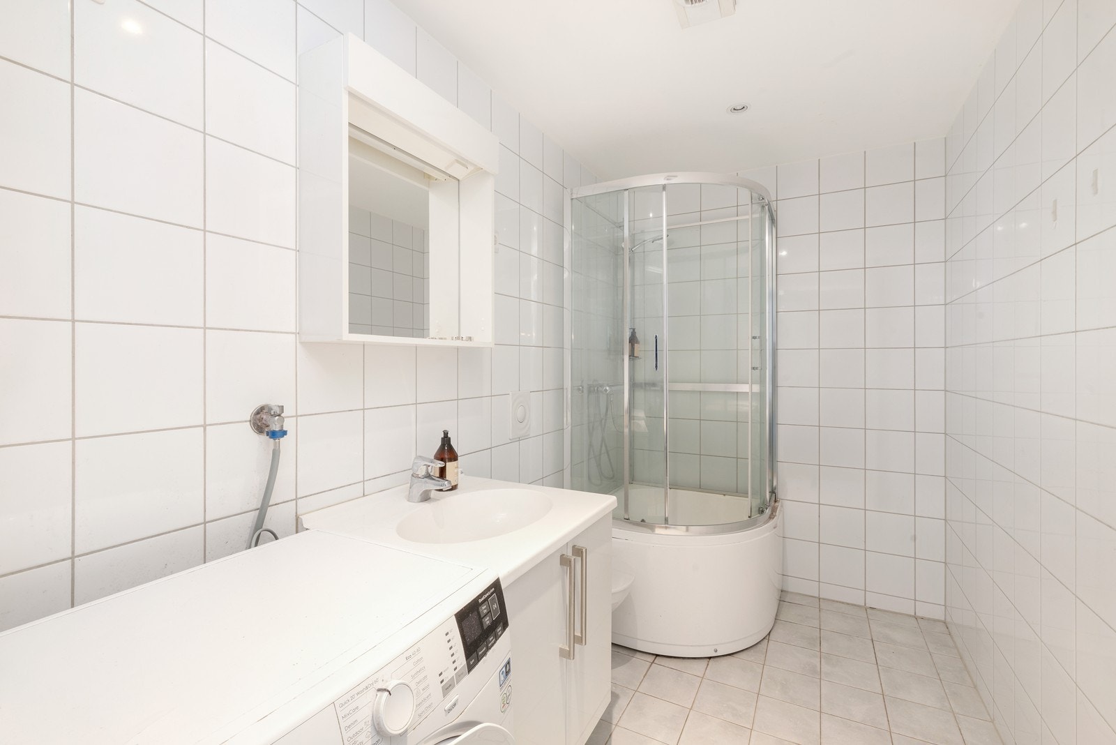 Flislagt baderom med servant med speil over, samt toalett og dusjkabinett. Det er også opplegg og plass til vaskemaskin/tørketrommel. Galleribilde