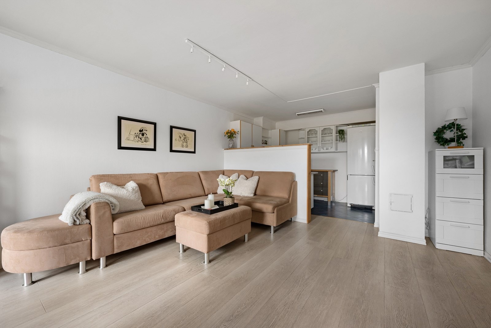 Rommet har tidløse overflater med malte vegger og laminatgulv (noe av stuen er etablert i areal som opprinnelig var bod) Galleribilde